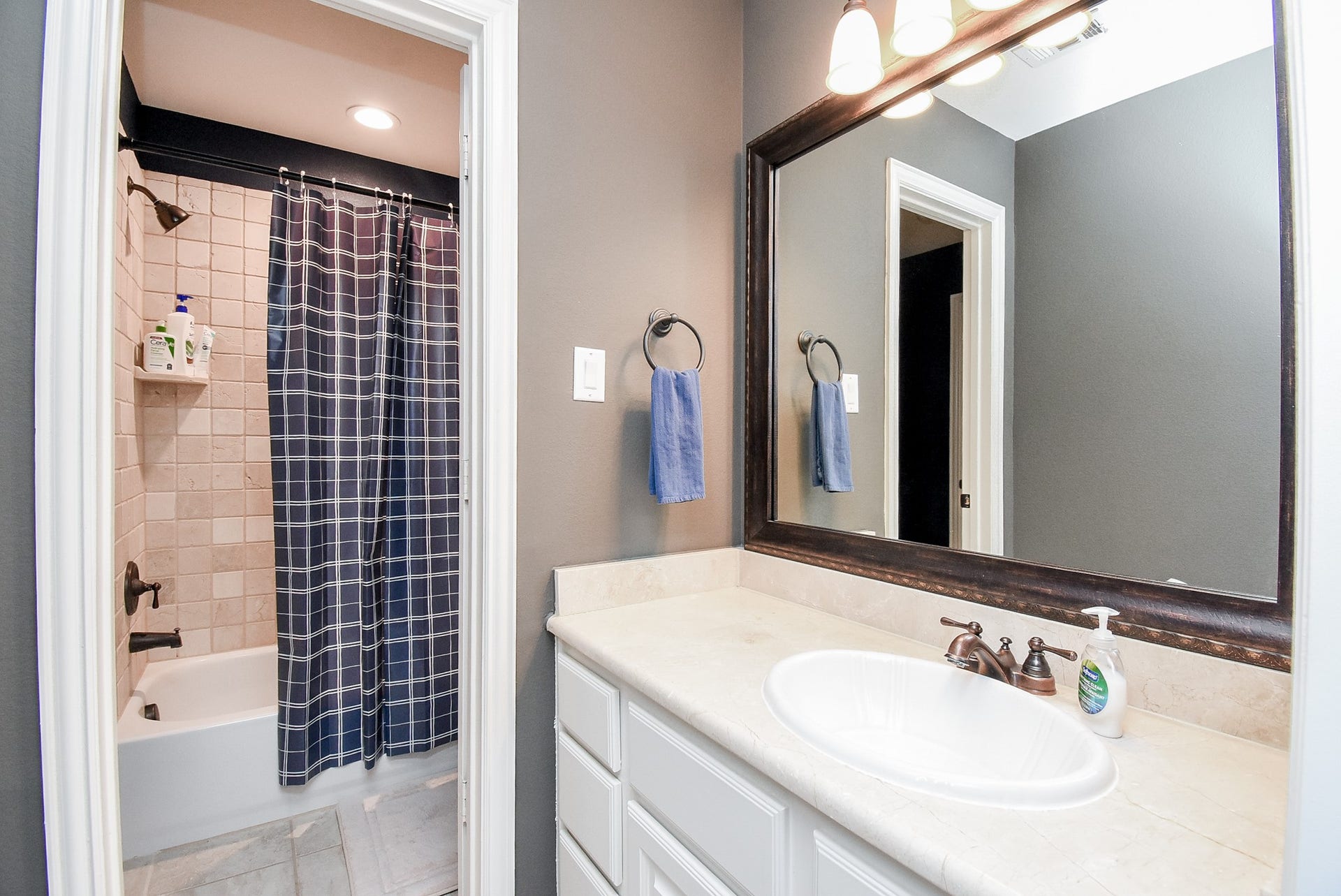 Vanity two for bedroom three shows the pretty tub/shower area. Spacious vanity and framed mirror. Lots of storage.