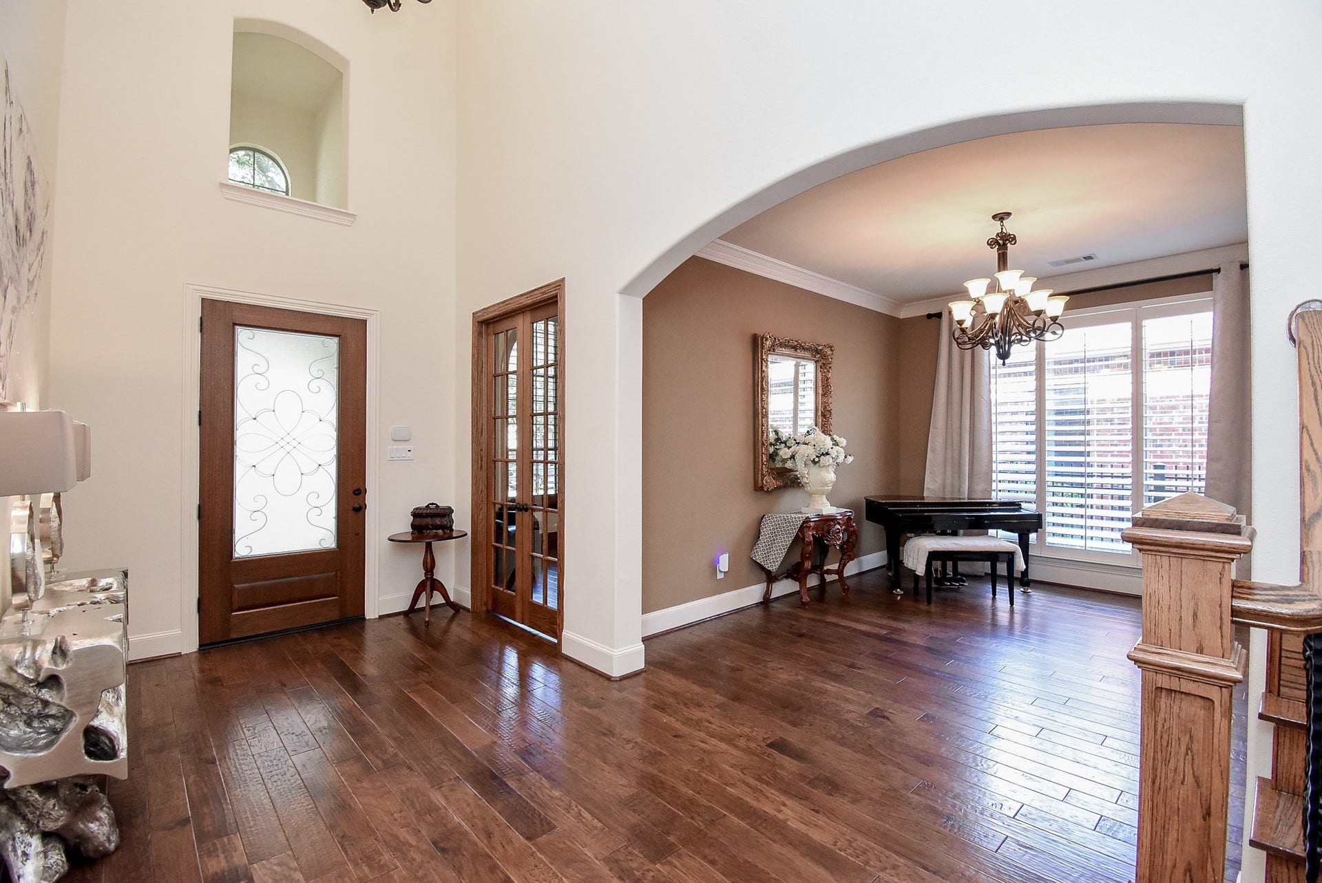 French Doors to the study are shown in this photo. The elegant dining room has contrasting molding, plantation shutters and pretty draperies.