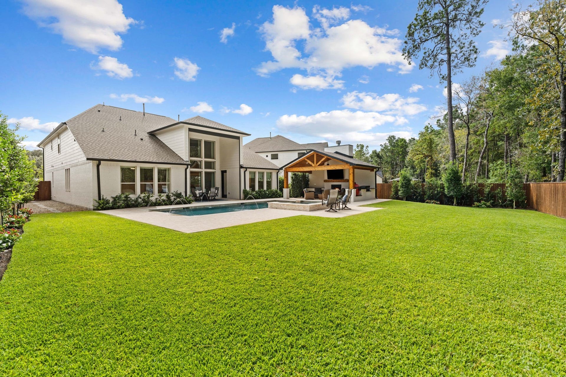 Backyard oasis featuring a vaulted cabana w/fireplace & outdoor kitchen, sparkling heated pool with tanning ledge, raised spa, elegant water features, and expansive travertine decking. Surrounded by lush landscaping and a wooded greenbelt, and hardscape side yards for low maintenance--this unusually large backyard offers exceptional privacy and a true resort-style experience!
