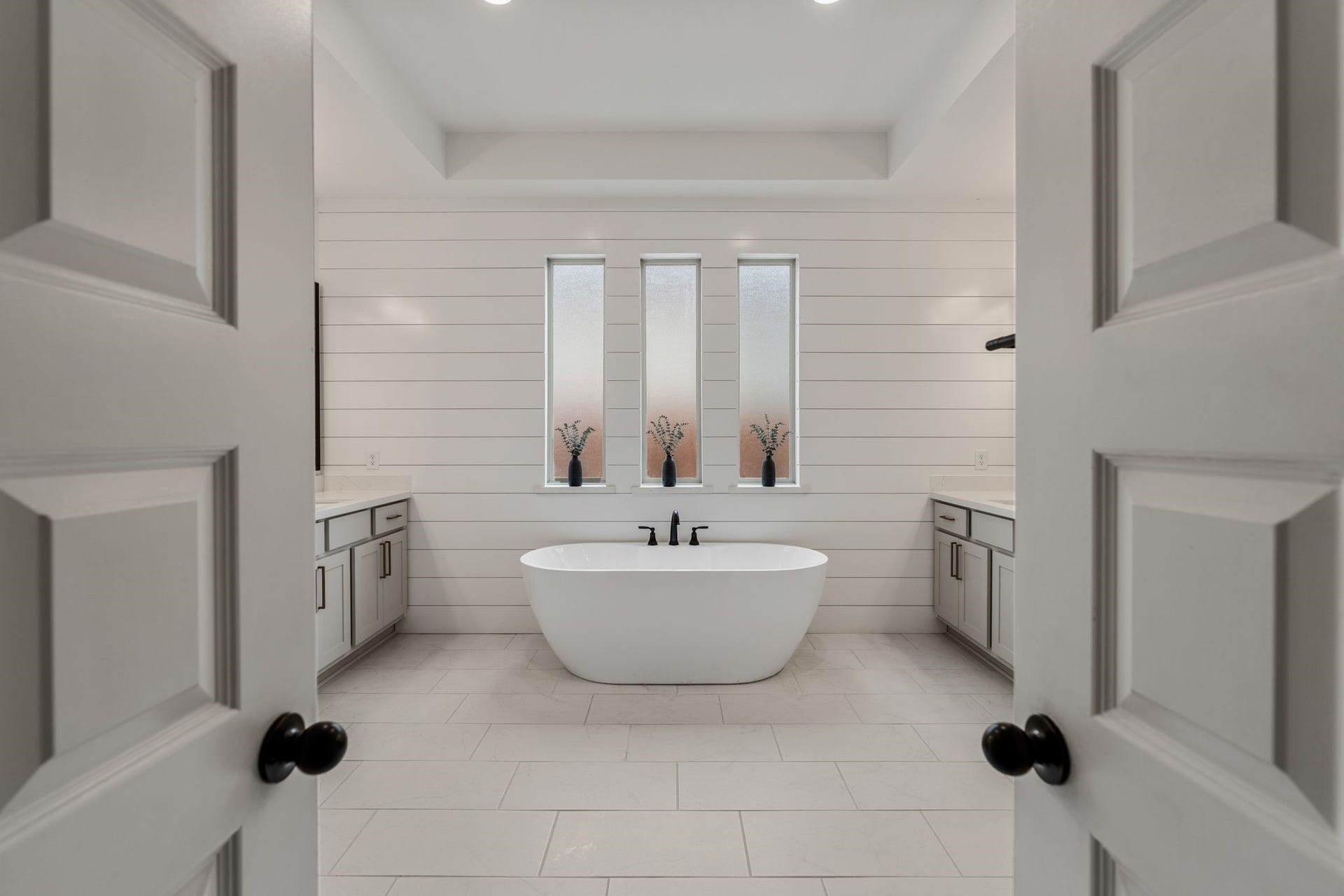 Luxurious, spa-inspired primary bath featuring a stunning freestanding soaking tub, elegant shiplap accent wall