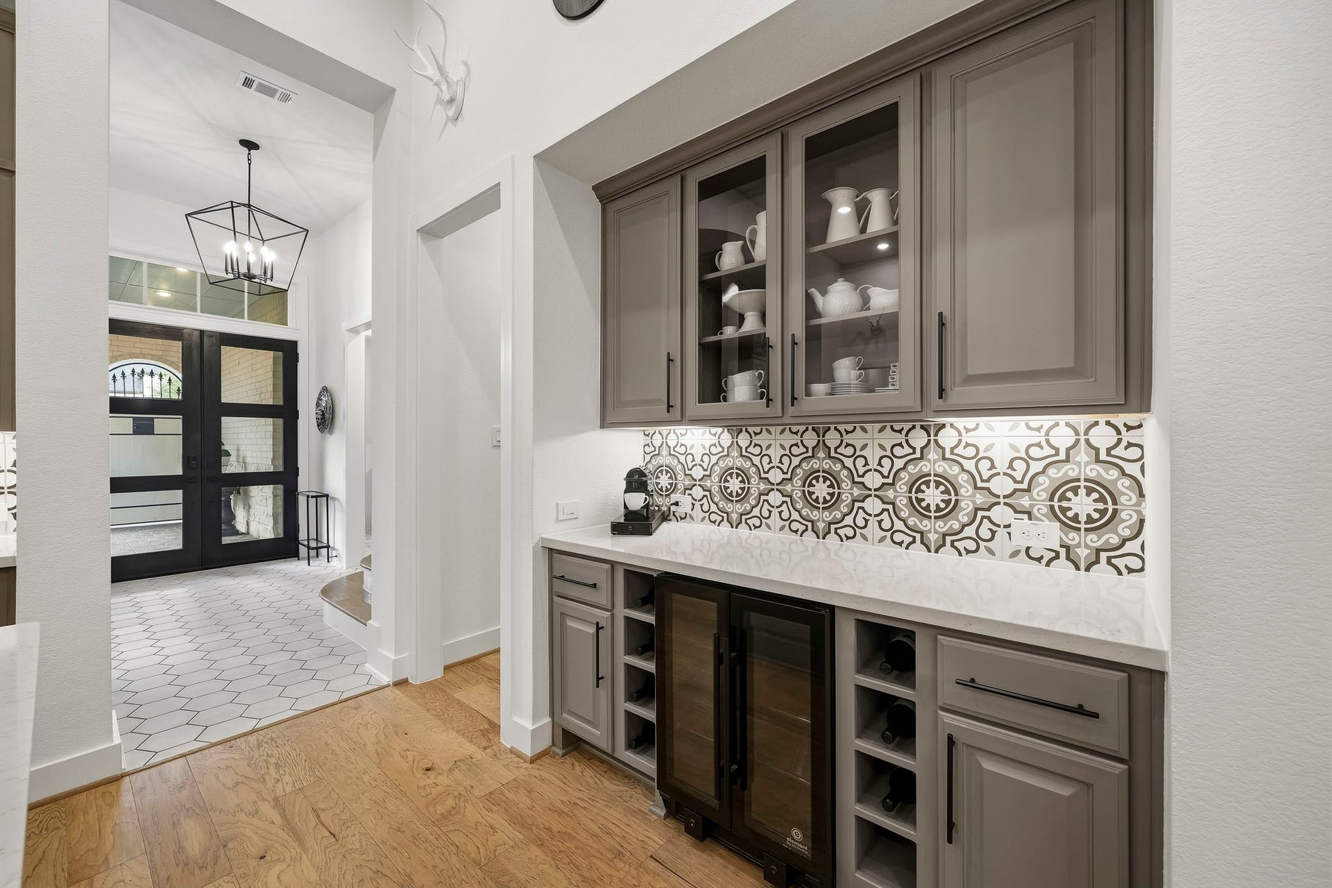 2514 Heritage Park Drive, Missouri City, TX 77459 The separate dry bar with cabinetry above is designed as a sophisticated extension of the kitchen, equally suited as a dry bar, coffee station or serving area. Quartz countertops, a decorative tile back splash, space for a wine refrigerator, glass-front display cabinetry and under mount lighting create a custom, high-end space ideal for entertaining and everyday convenience.