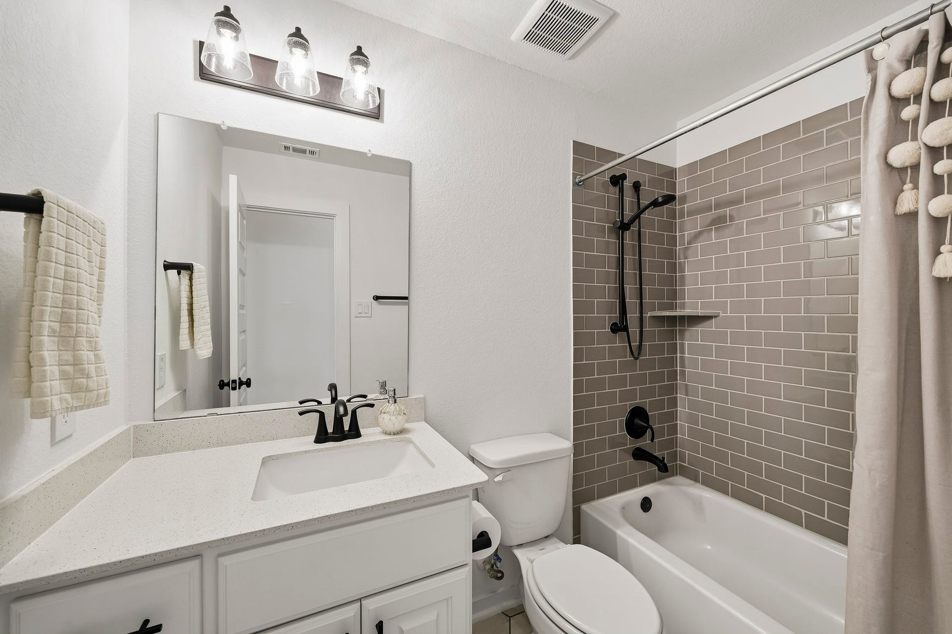 2514 Heritage Park Drive, Missouri City, TX 77459 The fourth full bathroom is finished with hexagonal tile flooring, a Quartz-topped vanity with mirror and lighting above and a tub/shower combination accented by a classic subway tile surround.
