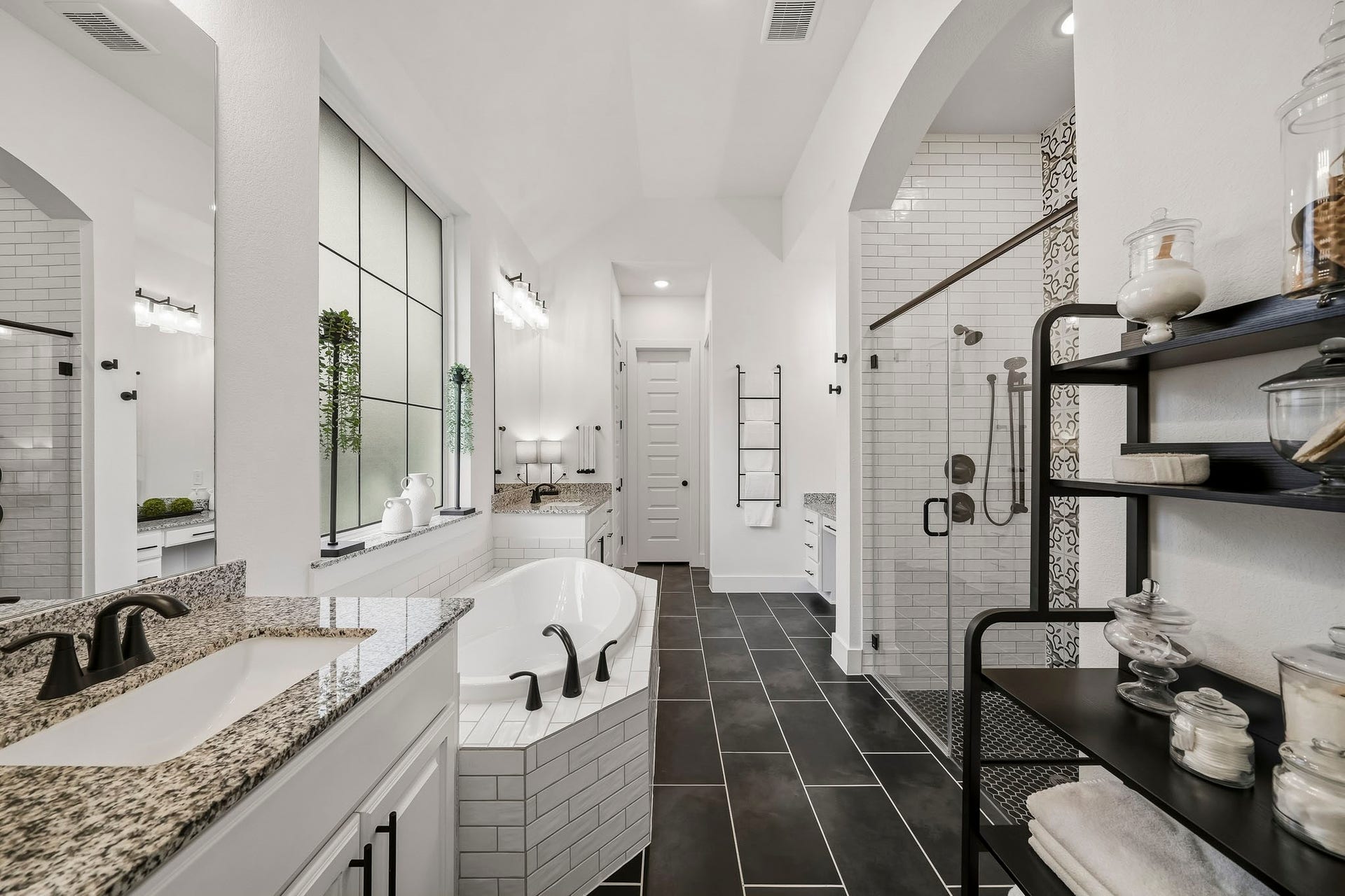 2514 Heritage Park Drive, Missouri City, TX 77459 The primary bath showcases designer 12" x 24" tile floors, dual sinks with granite countertops, and a deep soaking tub framed by obscure glass with a classic subway tile surround, creating a spa-inspired setting with timeless appeal.