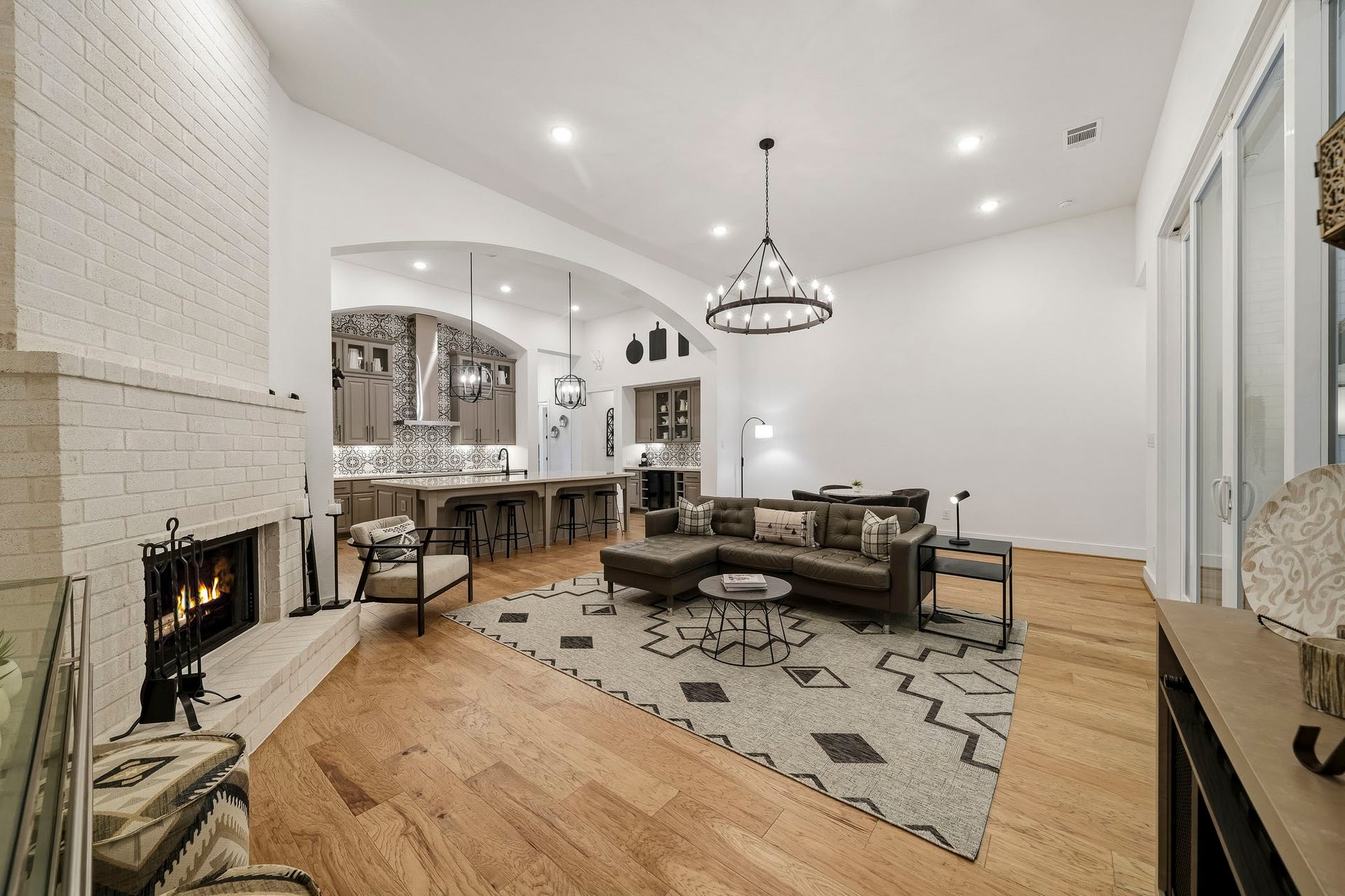 2514 Heritage Park Drive, Missouri City, TX 77459 The living room exudes understated luxury with rich hardwood flooring, dramatic soaring ceilings, recessed lighting and a striking statement chandelier that brings an elevated sense of style and sophistication to the space.