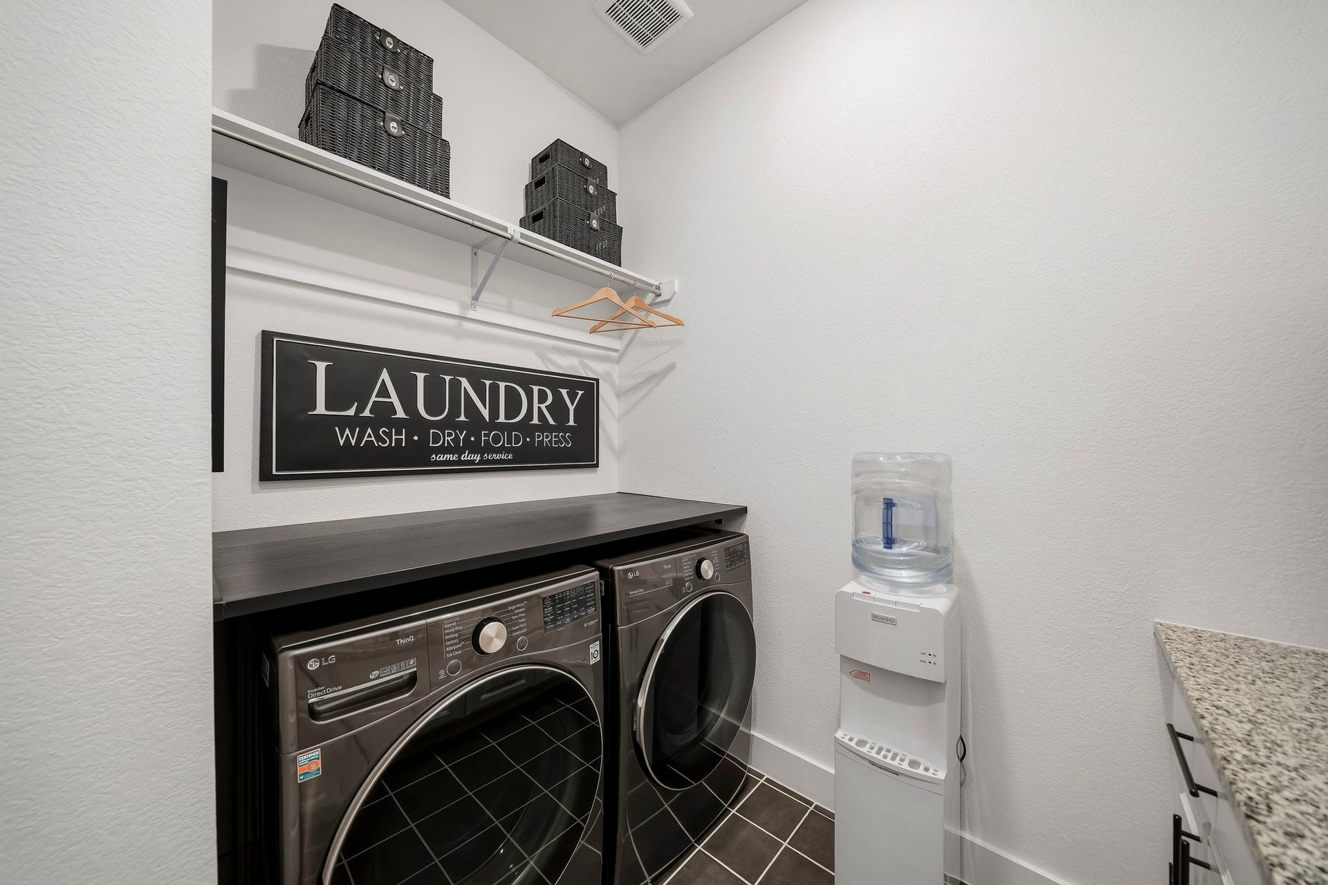 2514 Heritage Park Drive, Missouri City, TX 77459 The spacious utility room extends beyond everyday function with tile floors, a folding counter, shelf and hanging rod along with recessed lighting that adds a clean finish to the space.