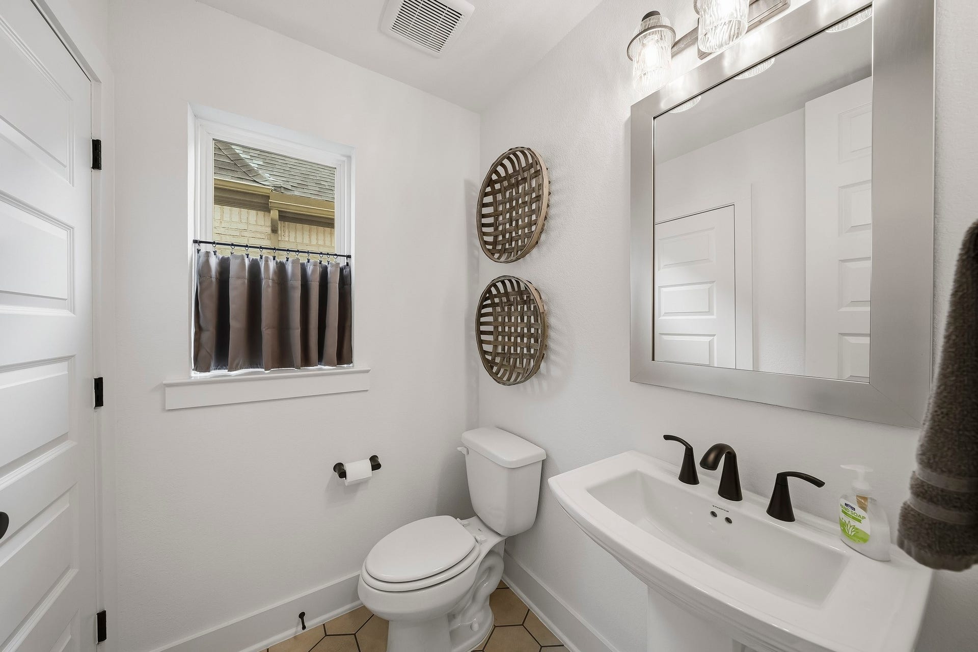 2514 Heritage Park Drive, Missouri City, TX 77459 Tucked just off the kitchen hallway, the powder room showcases hexagonal tile flooring, a classic pedestal sink, decorative mirror and natural light from a private window. A walk-in closet adds unexpected storage and everyday convenience.