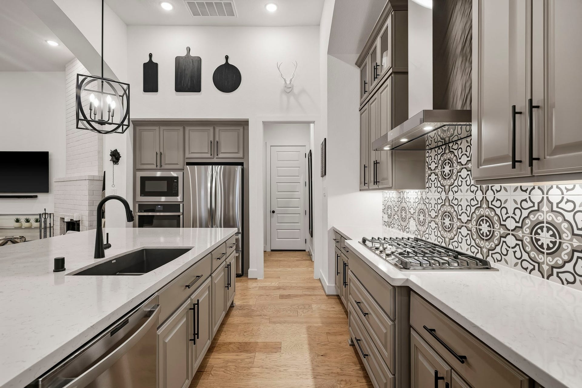 2514 Heritage Park Drive, Missouri City, TX 77459 Designed with the craftsmanship and detailing expected from home with so many upgrades, the kitchen blends refined finishes with high-performance function. A dual-basin composite sink, five-burner GE Caf cooktop with S/S chimney vent, custom cabinetry, generous prep space and carefully selected fixtures create a polished yet highly livable setting for everyday cooking and effortless entertaining.