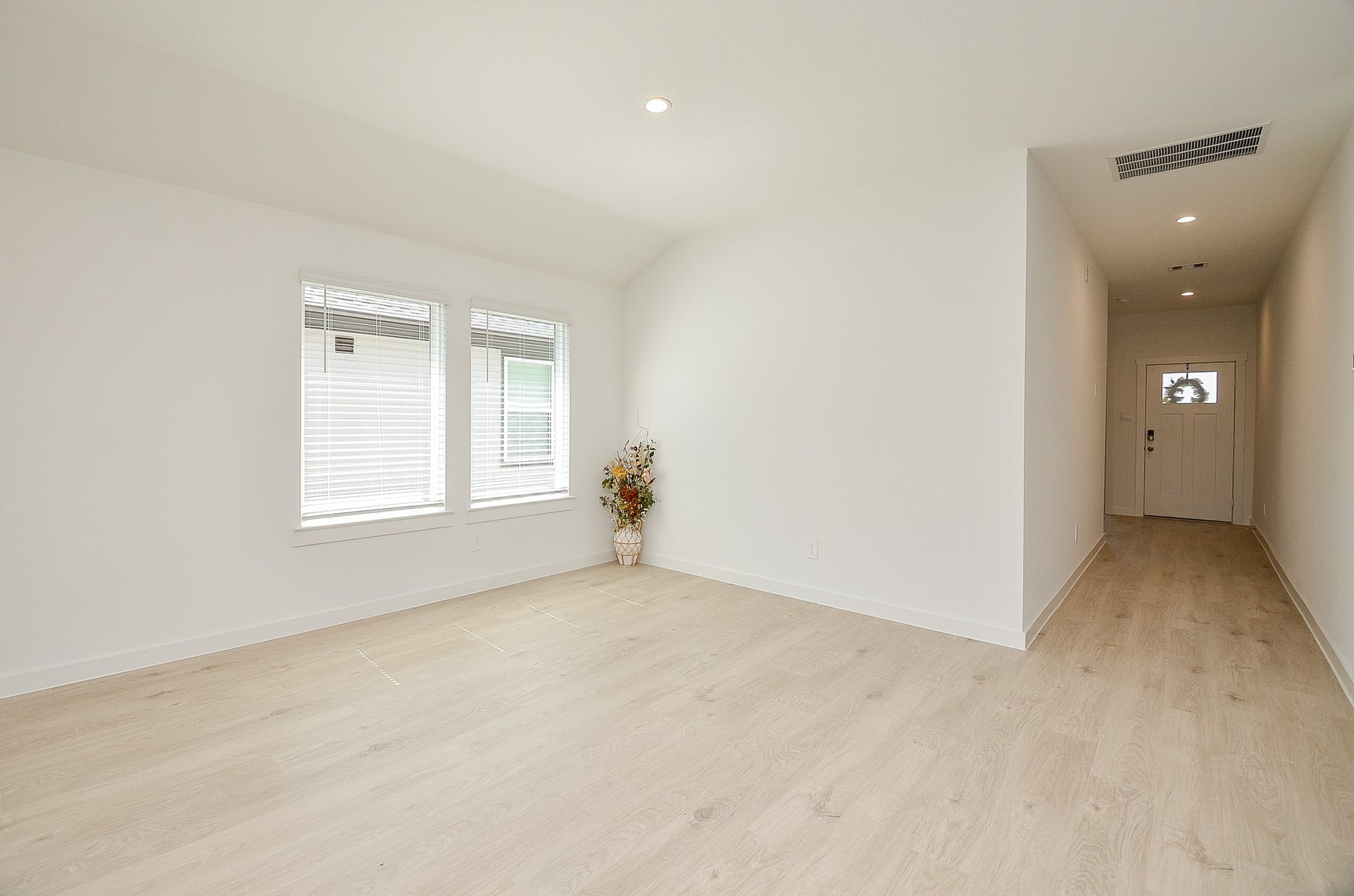 7814 Bel Fiore Drive, Richmond, TX 77406 Bright and airy living space featuring sleek wood flooring, ample natural light from large windows, and a welcoming entryway.