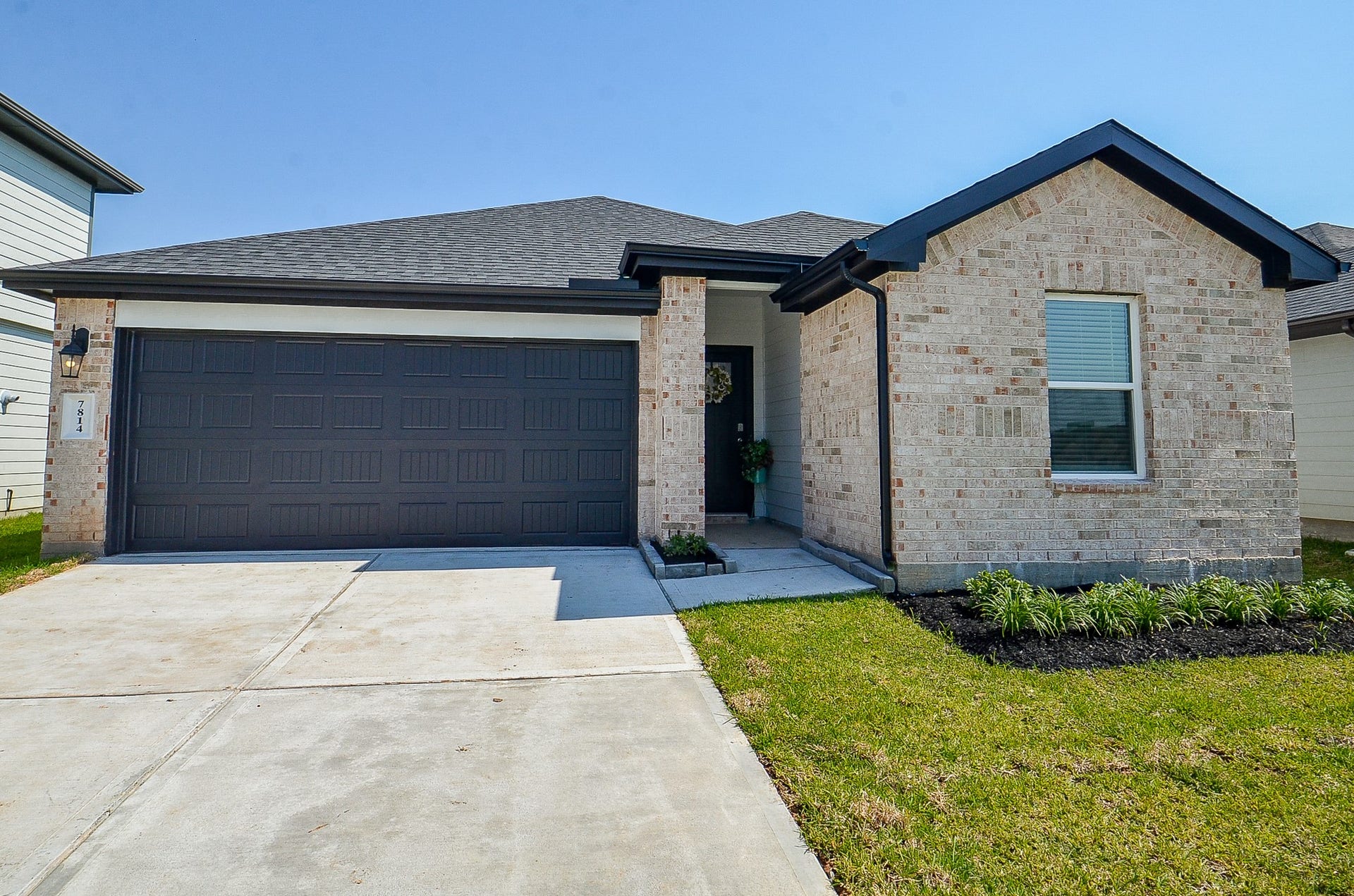 7814 Bel Fiore Drive, Richmond, TX 77406 Charming single-story home featuring a modern brick exterior, double garage, and a welcoming front entry with landscaped garden accents.