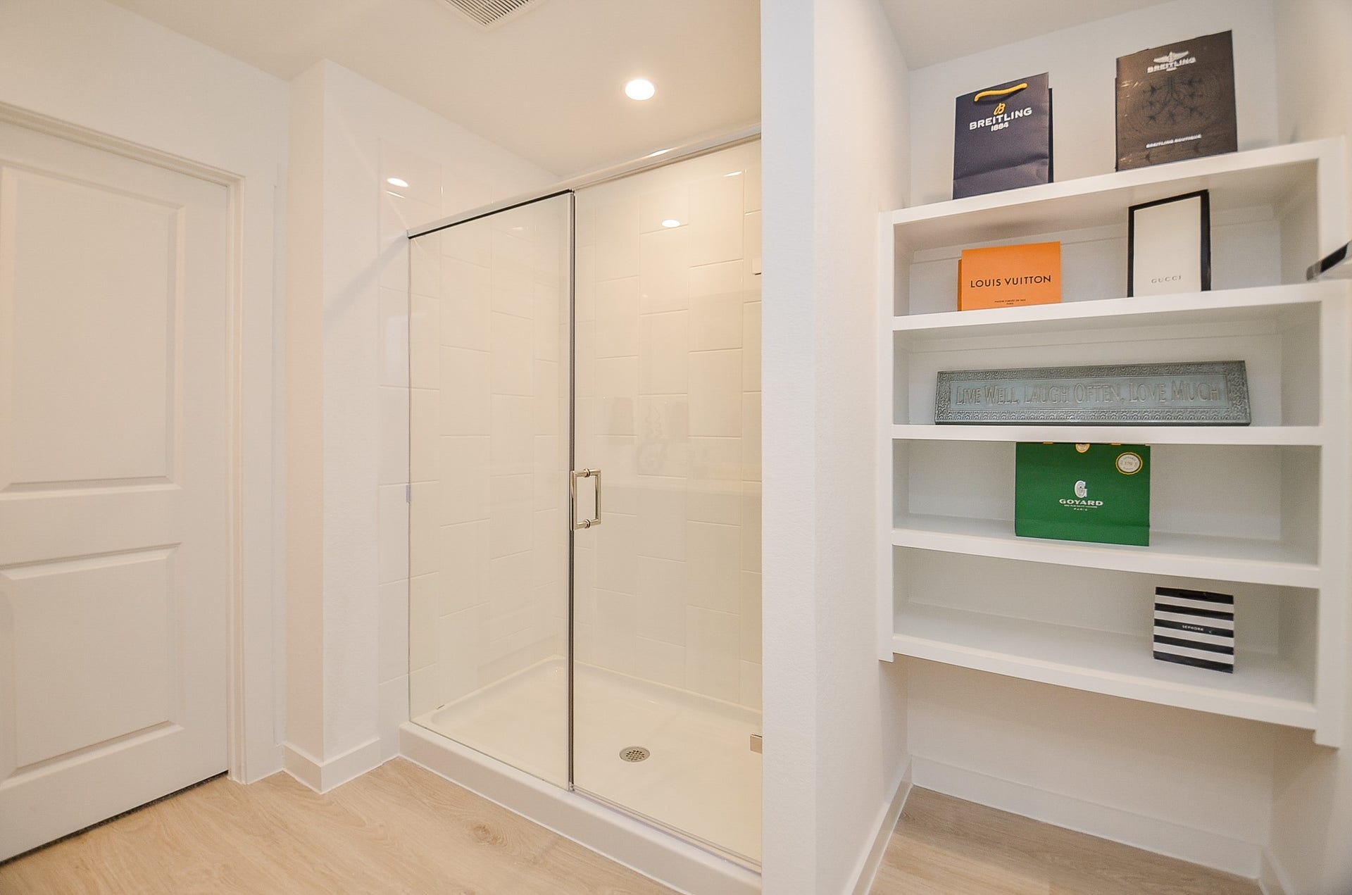 7814 Bel Fiore Drive, Richmond, TX 77406 Modern bathroom featuring a sleek glass-enclosed shower and built-in shelving for stylish storage.