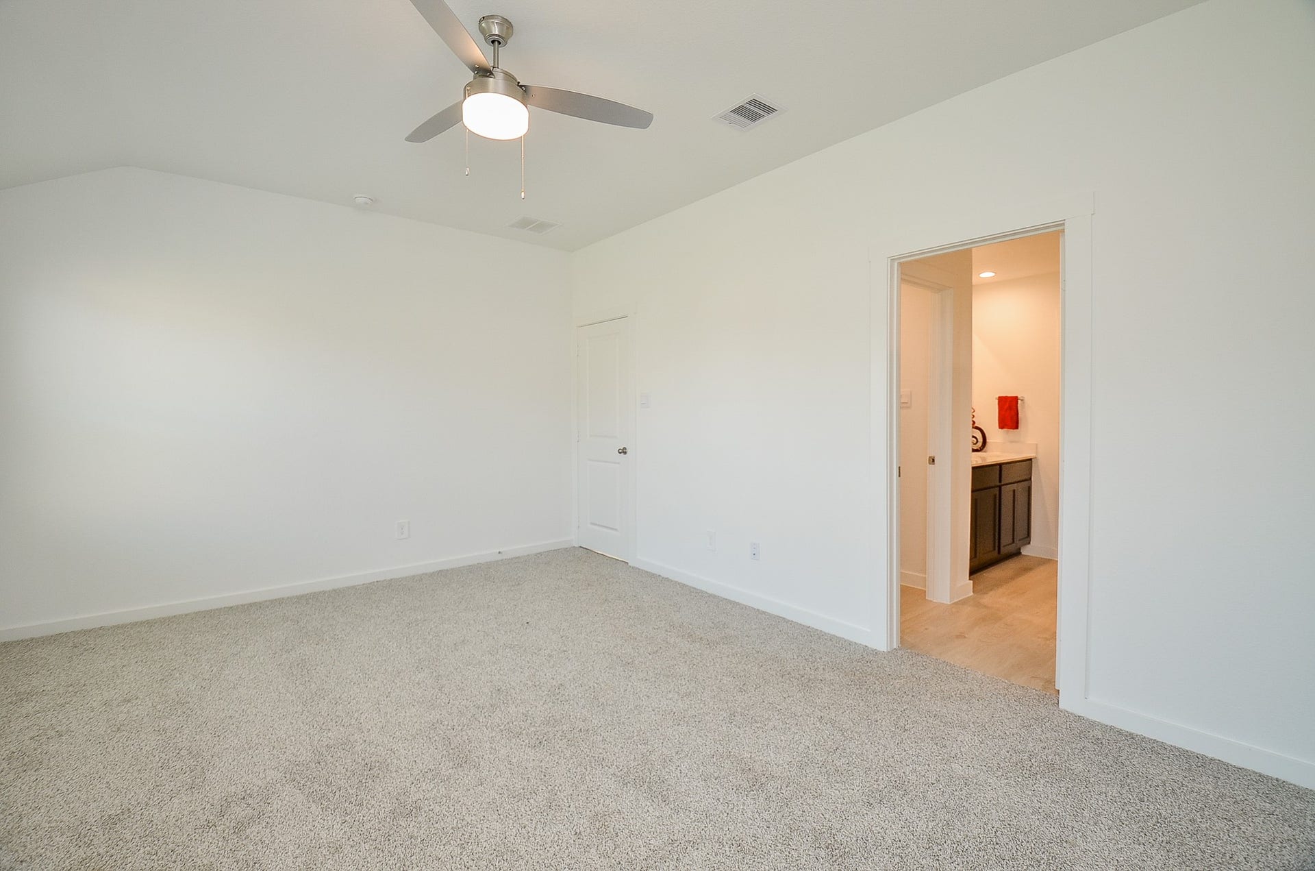 7814 Bel Fiore Drive, Richmond, TX 77406 Spacious bedroom with plush carpeting, modern ceiling fan, and an en-suite bathroom for added convenience.