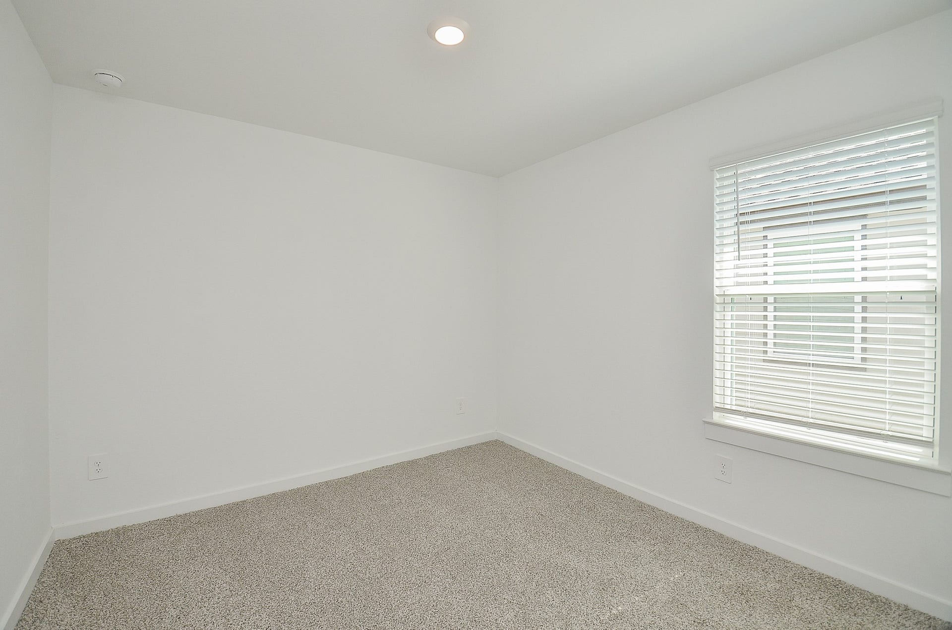7814 Bel Fiore Drive, Richmond, TX 77406 Bright and cozy room featuring soft carpet flooring and a window with blinds, perfect for a bedroom or home office.