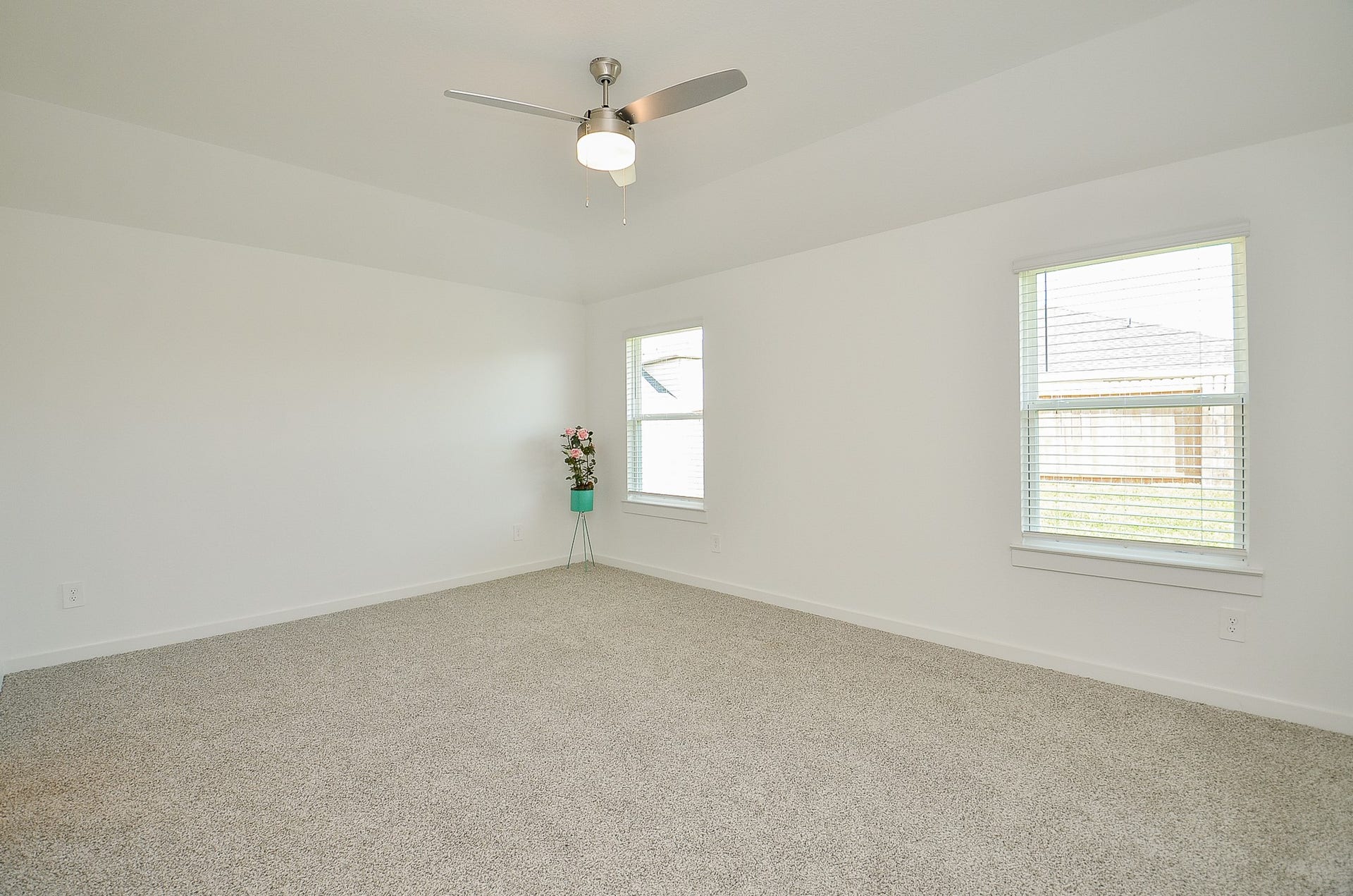 7814 Bel Fiore Drive, Richmond, TX 77406 Spacious, light-filled room with neutral carpeting and modern ceiling fan, ideal for a cozy retreat or versatile living space.