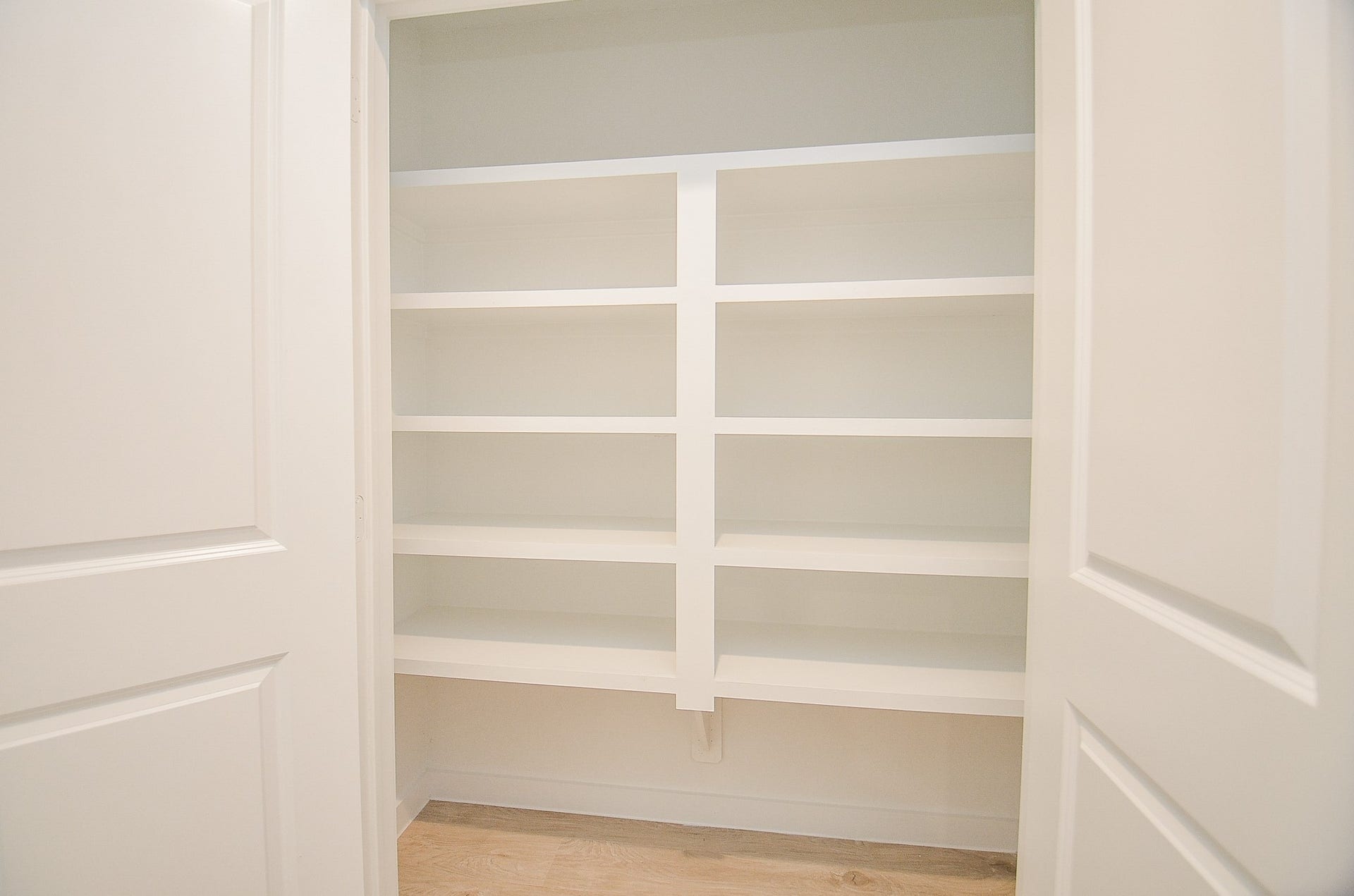7814 Bel Fiore Drive, Richmond, TX 77406 Spacious pantry with sleek white shelving, perfect for organized storage and easy access to kitchen essentials.