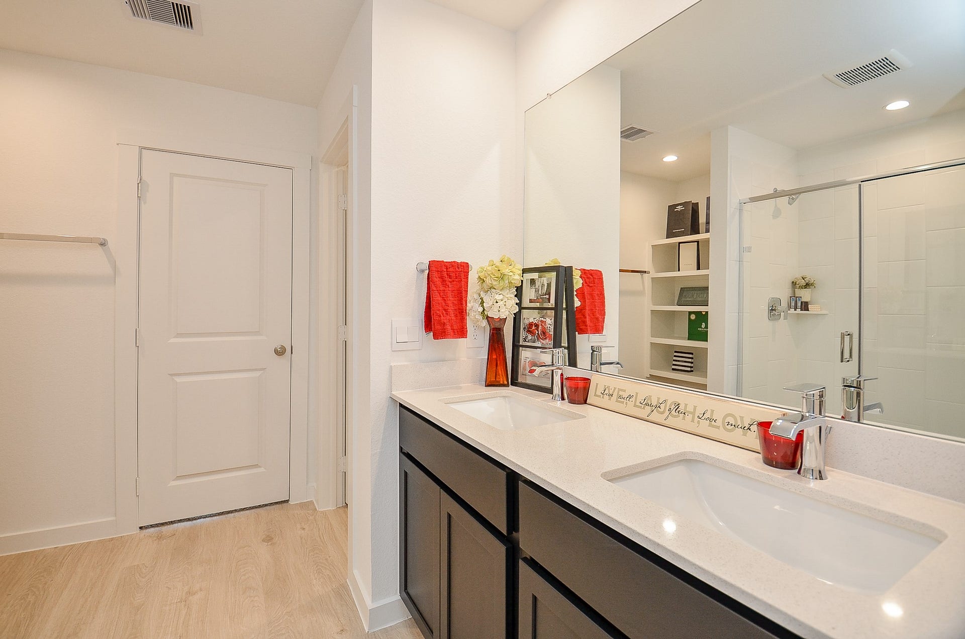 7814 Bel Fiore Drive, Richmond, TX 77406 Modern bathroom featuring a dual-sink vanity with sleek countertops, spacious glass-enclosed shower and ample storage.