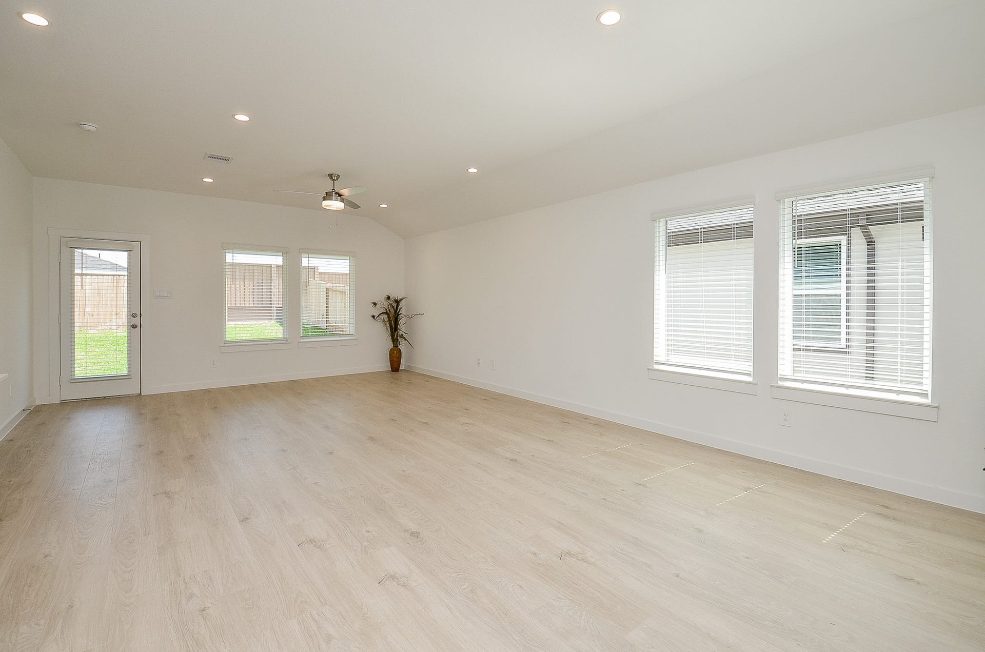 7814 Bel Fiore Drive, Richmond, TX 77406 Spacious and bright living area with sleek wood flooring, recessed lighting, and large windows offering abundant natural light.