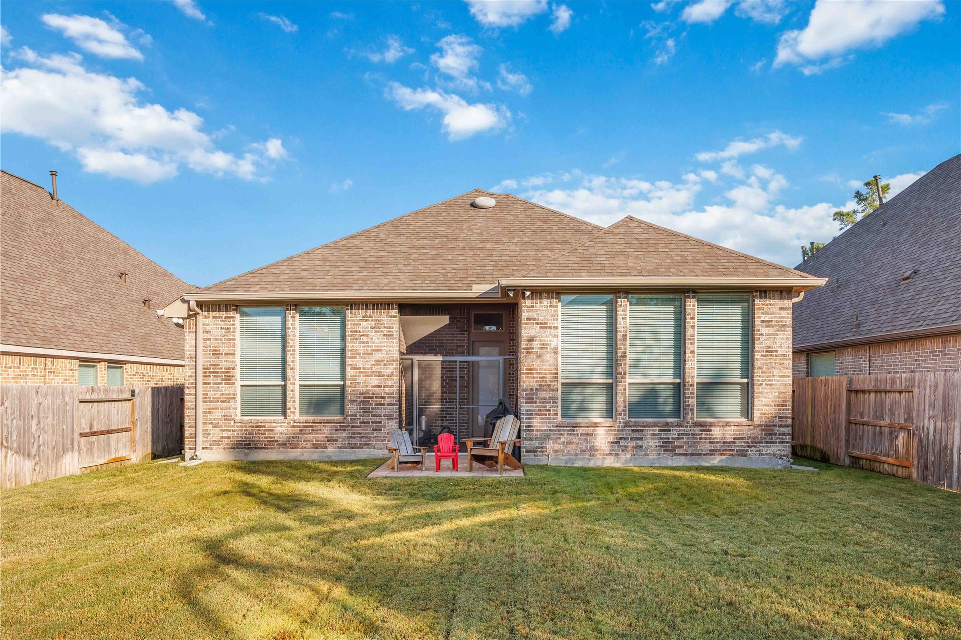 12610 Woodbourne Forest Drive, Humble, TX 77346 This is a charming single-story brick home with a spacious backyard. The property features a small patio area, perfect for outdoor seating. It offers privacy with fenced boundaries and has well-maintained grass, ideal for relaxation or play.