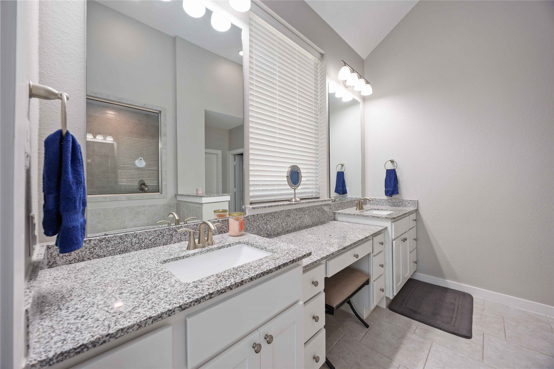 12610 Woodbourne Forest Drive, Humble, TX 77346 This bathroom features dual sinks with granite countertops, ample cabinet space, and a large mirror with modern lighting. The neutral tile flooring and soft wall colors create a clean, inviting atmosphere.