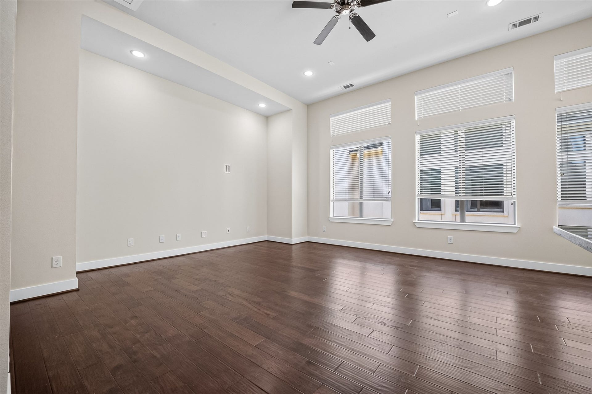 40 N Hutcheson Street, Houston, TX 77003 Spacious living area with rich hardwood floors, large windows for ample natural light, and a modern ceiling fan for comfort.