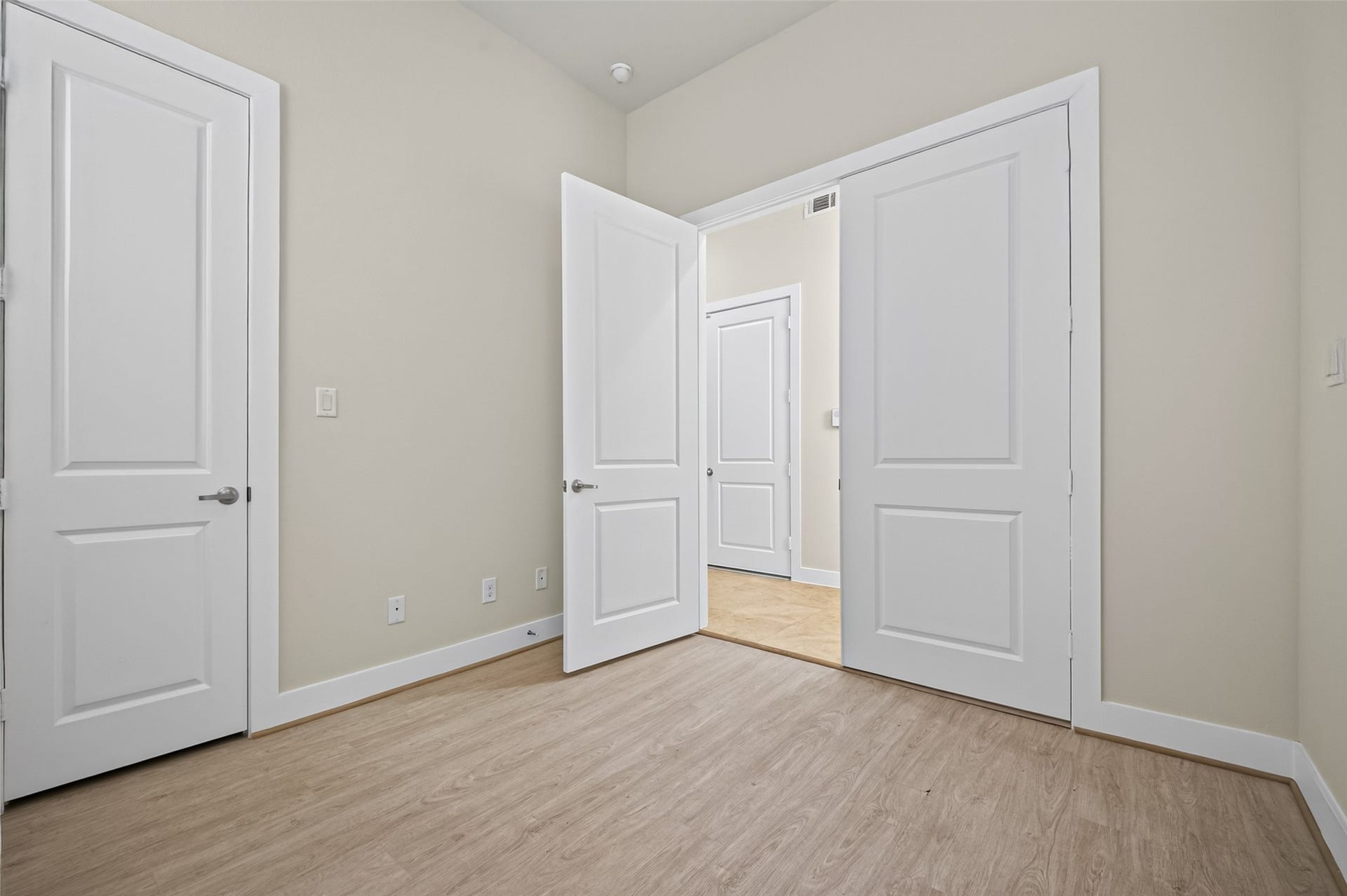 40 N Hutcheson Street, Houston, TX 77003 Bright room with light wood flooring and crisp white doors, offering a clean and modern atmosphere.