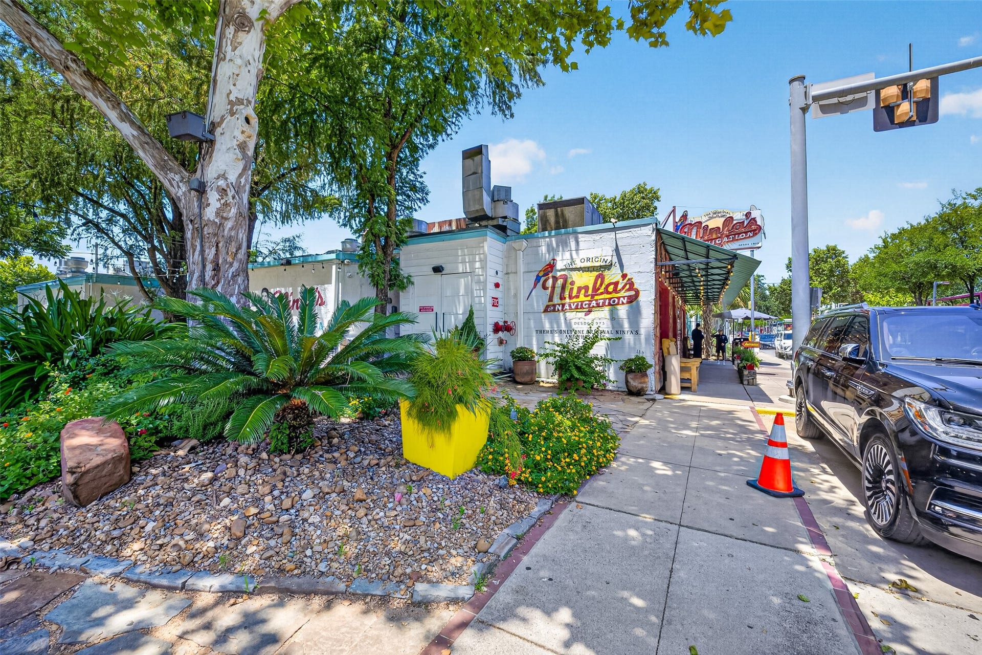 40 N Hutcheson Street, Houston, TX 77003 Ninfas a charming eatery with a vintage vibe, surrounded by lush greenery and vibrant planters, offering a welcoming sidewalk setting.