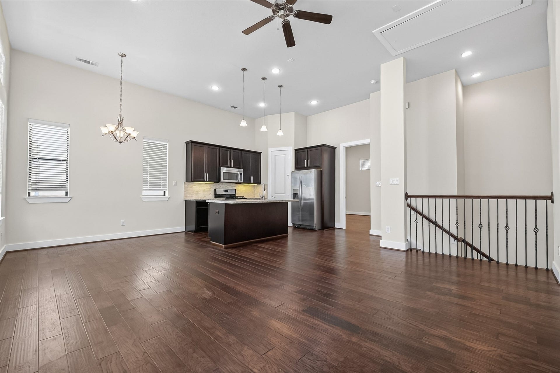 40 N Hutcheson Street, Houston, TX 77003 Spacious open-concept living area featuring rich hardwood floors, a modern kitchen with stainless steel appliances, and elegant lighting fixtures, perfect for entertaining.