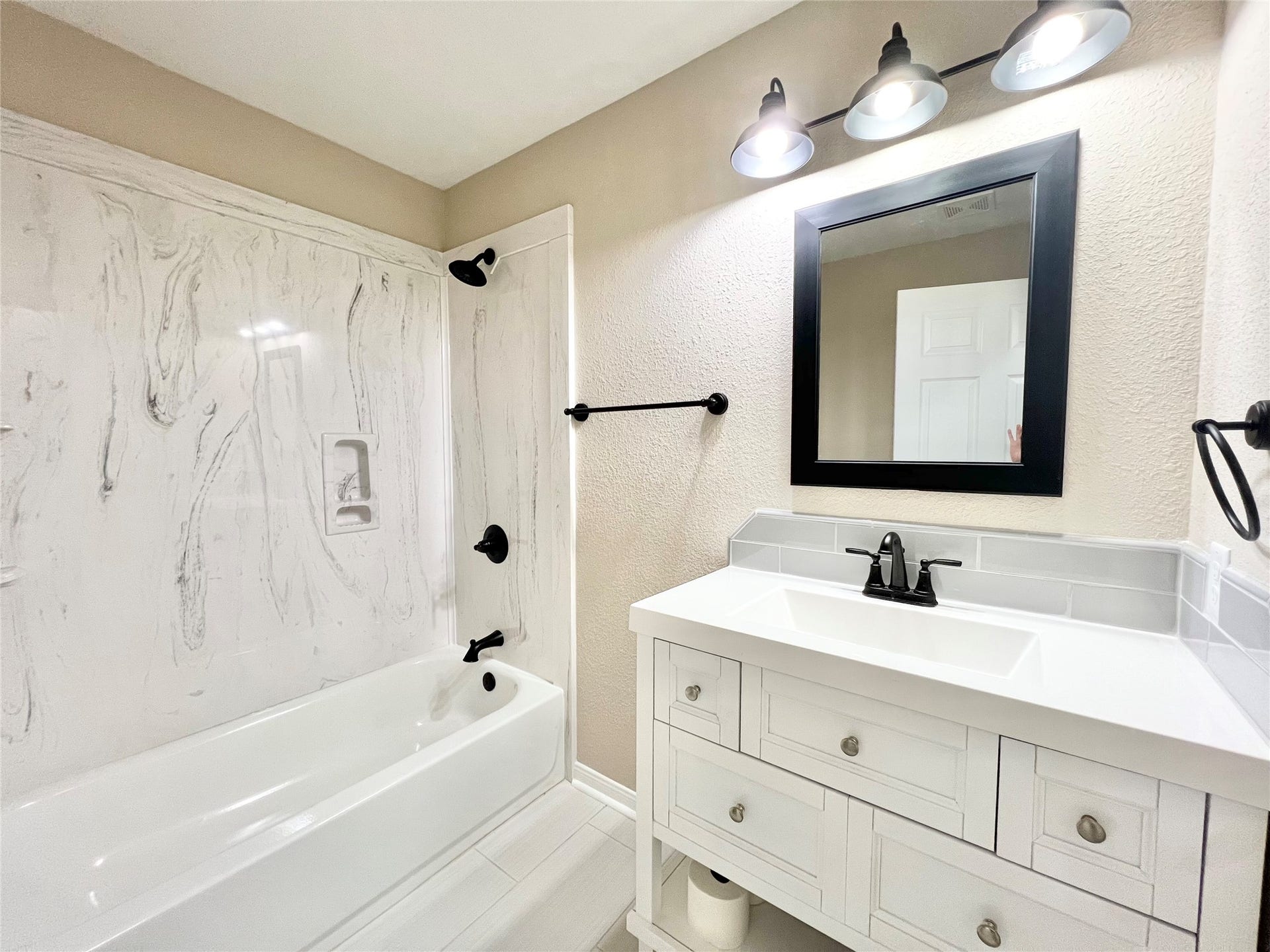 3806 Peck Street, Santa Fe, TX 77517 Guest bathroom has a tub/shower combo and large sink/vanity with extra storage space to the left of the shower.