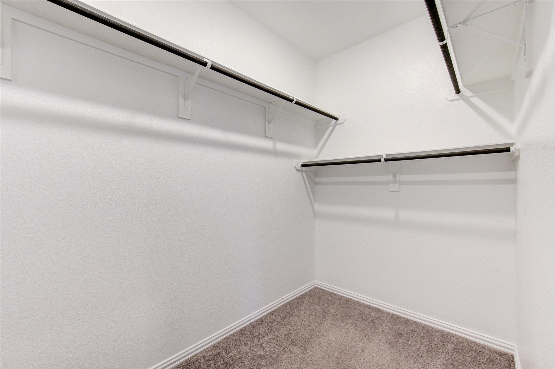 Spacious primary walk-in closet with plenty of hanging and storage space