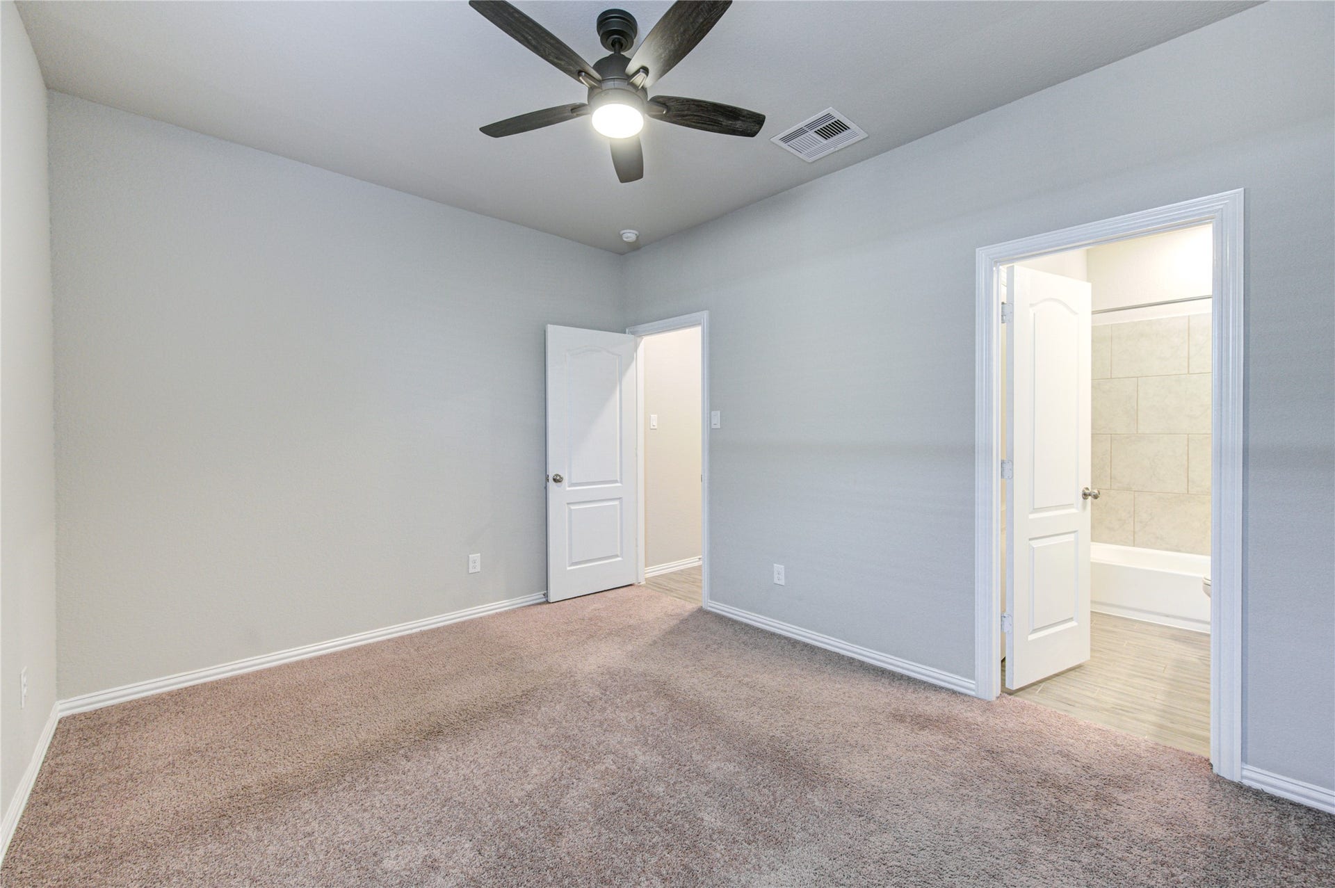 Secondary bedroom with ceiling fan and en suite bathroom