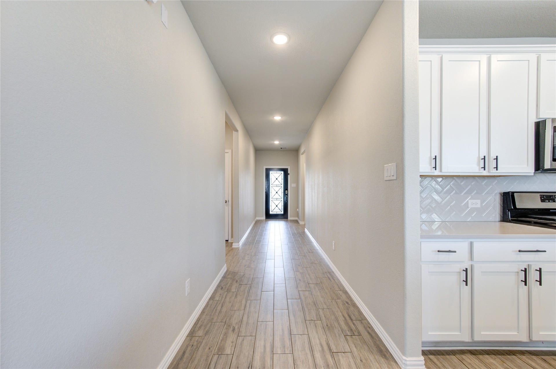 Open layout with a welcoming entry, wood-look tile flooring, and recessed lighting throughout