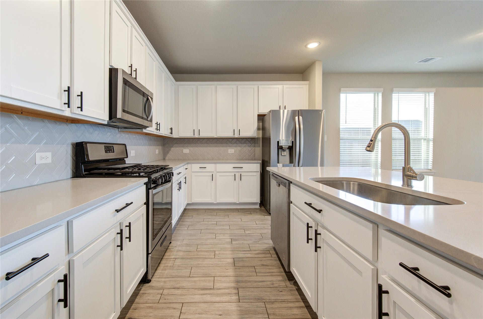 Stylish kitchen with a large island, abundant cabinet space, stainless steel appliances, and refrigerator included