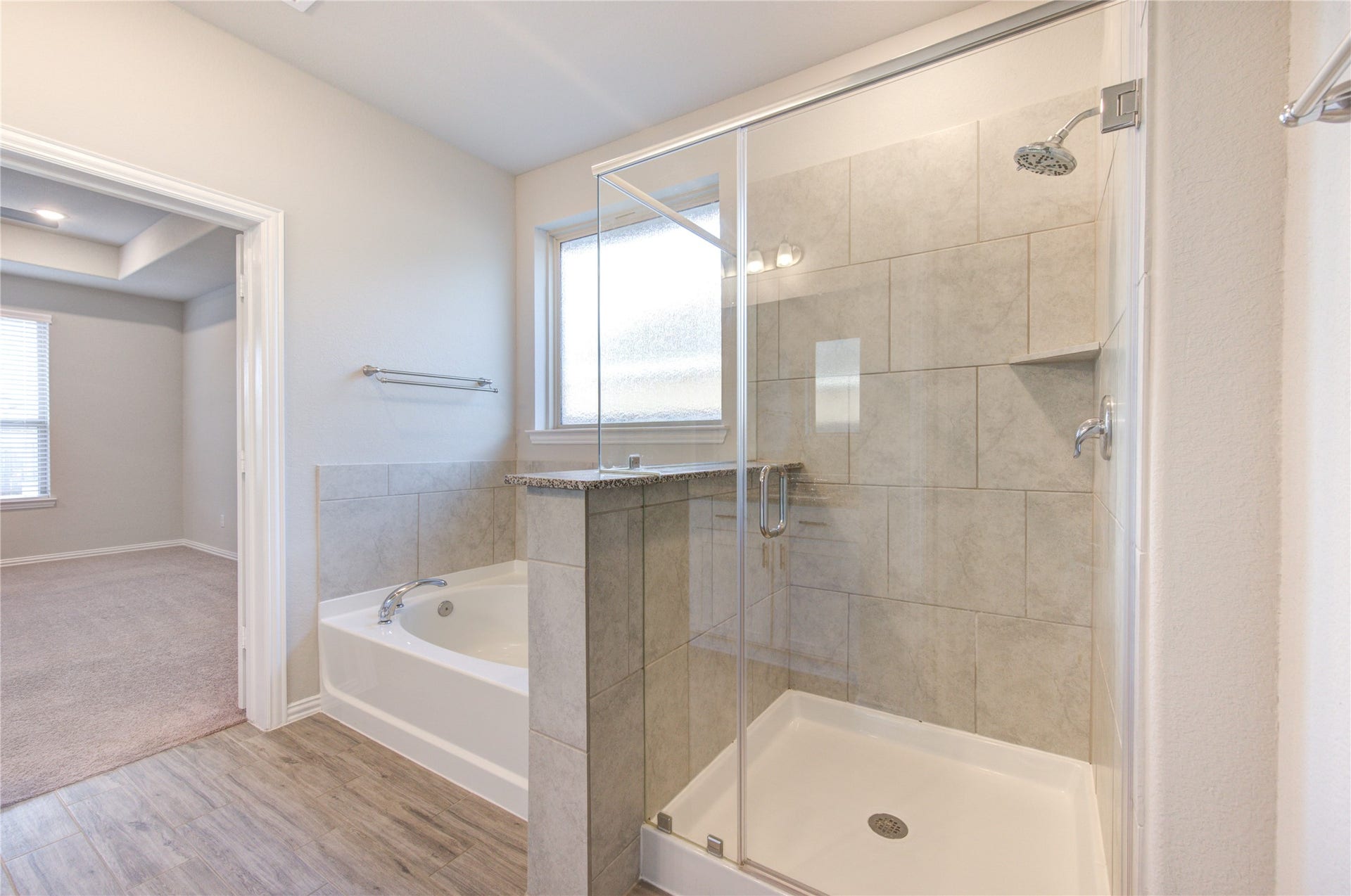 Primary bath featuring a separate walk-in shower and soaking tub