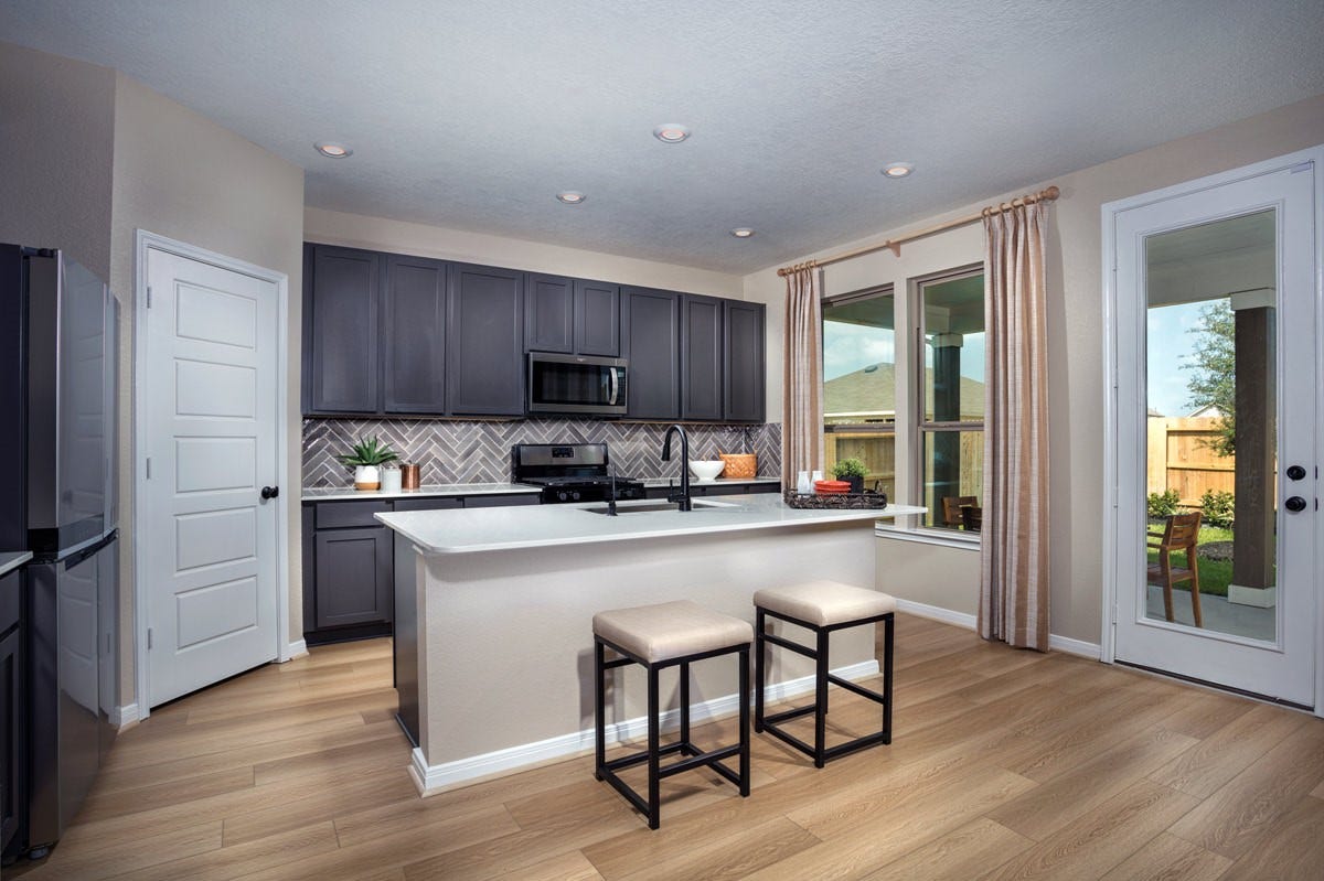 2019 Ardani Lane, Fresno, TX 77545 This spacious kitchen boasts Woodmont Dakota cabinets in Black Fox stain, Quartz Ariel countertops, stainless steel Whirlpool appliances, a modern Daltile backsplash, recessed lighting, an extended breakfast bar countertop, and a pantryall overlooking the expansive family room.