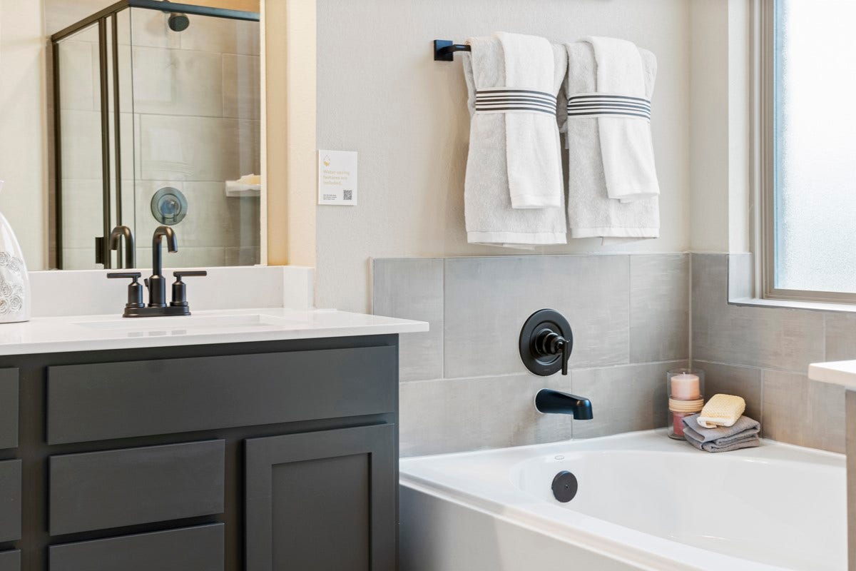 2019 Ardani Lane, Fresno, TX 77545 This stunningly updated primary bathroom is truly move-in ready! It features stained cabinetry with light countertops, dual sinks, a large mirror, high ceilings, custom paint, and sleek modern finishes throughout.