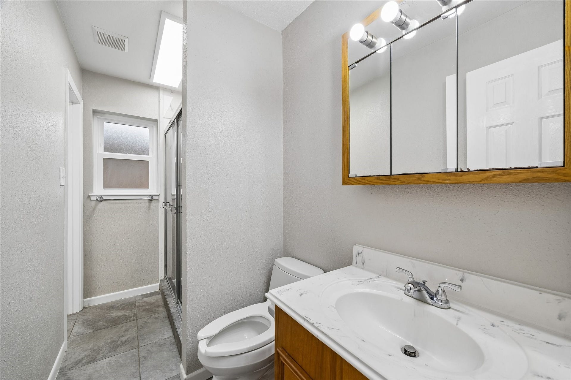 1110 E Rutgers Lane, Deer Park, TX 77536 Bathroom off of the hallway by first two bedrooms. Shower at the back right of the bathroom with sliding glass door.