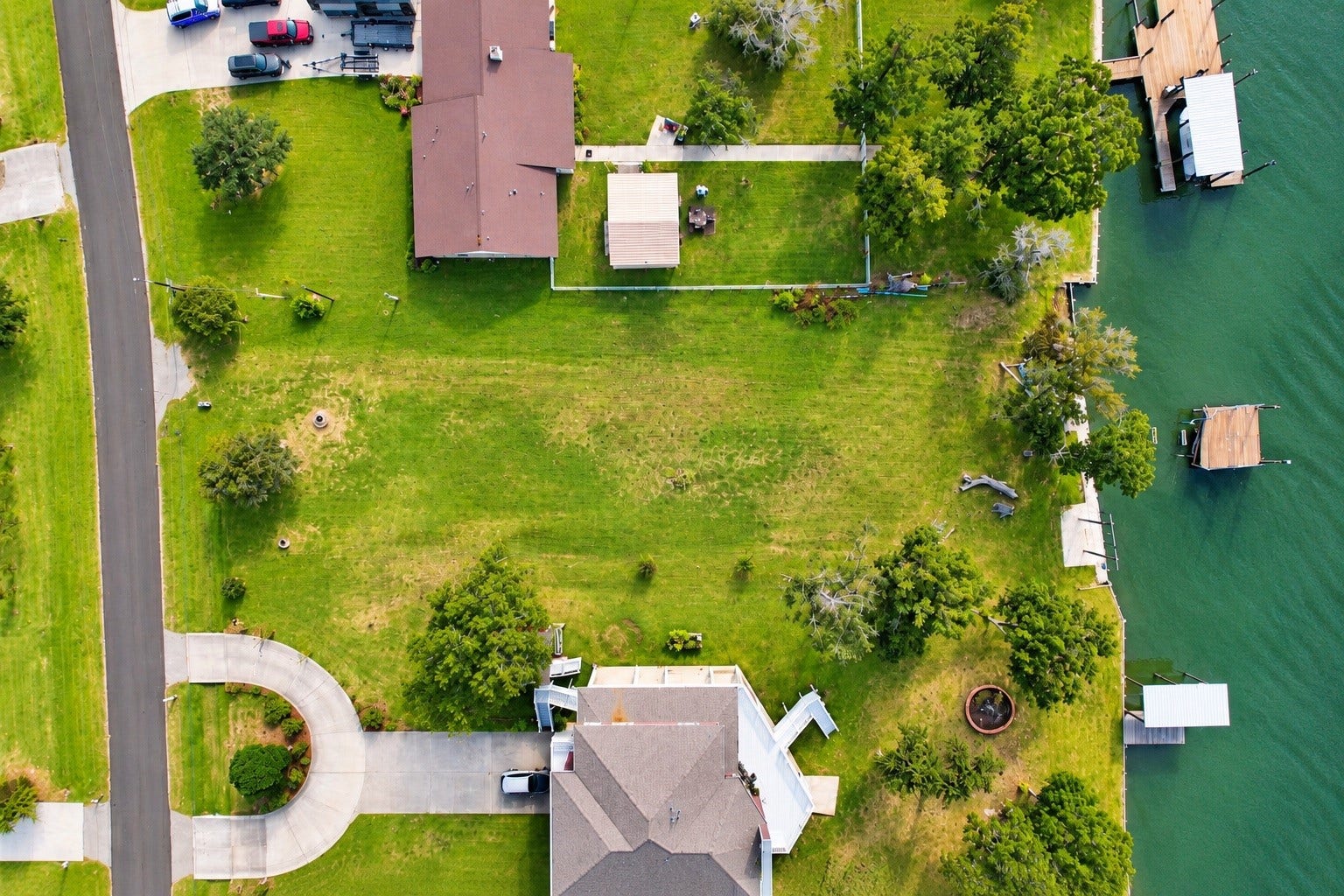 Spacious waterfront property with lush green lawns, private docks, and a serene setting, perfect for relaxation and outdoor activities.
