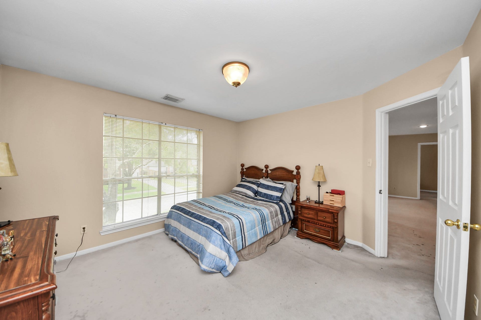 7015 Morningside Drive, Sugar Land, TX 77479 Cozy bedroom featuring a large window that fills the space with natural light, complemented by neutral walls and ample space for furnishings.