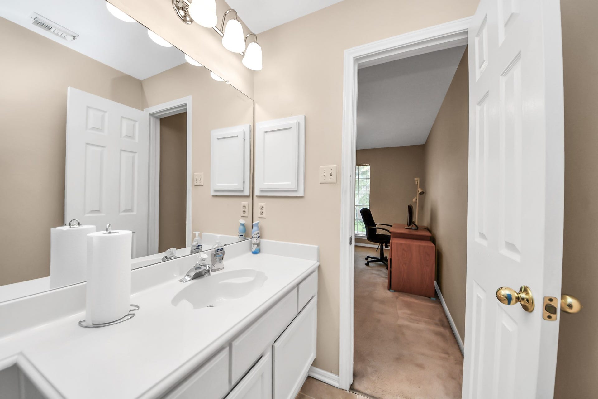 7015 Morningside Drive, Sugar Land, TX 77479 Bright bathroom featuring a large vanity with ample counter space, leading into a cozy office area with natural light.