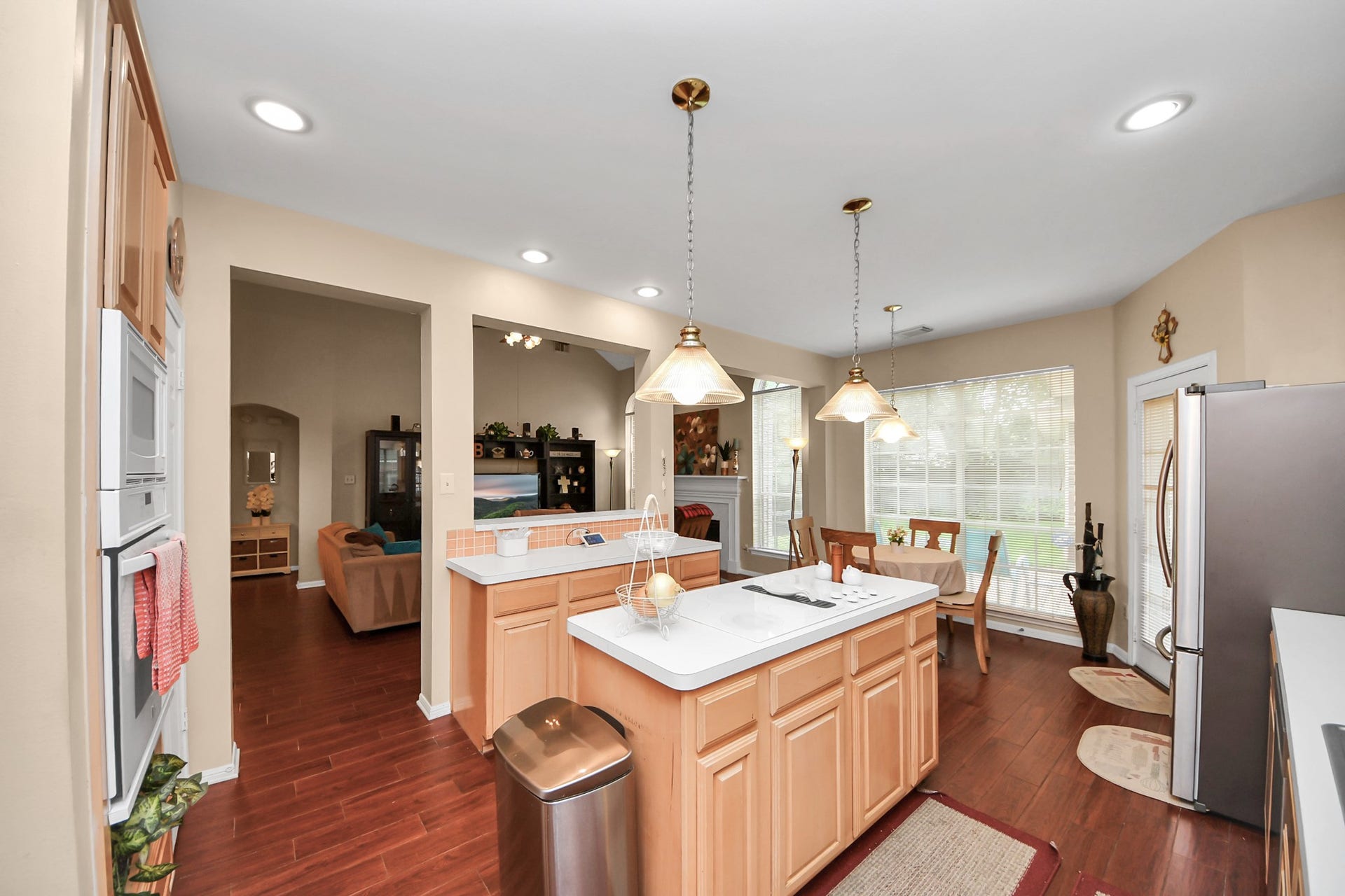 7015 Morningside Drive, Sugar Land, TX 77479 Spacious kitchen with a central island, pendant lighting, and plenty of natural light, seamlessly connecting to a cozy living area and dining space.