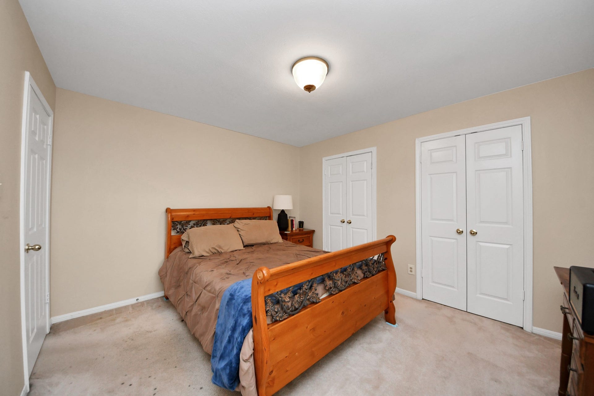 7015 Morningside Drive, Sugar Land, TX 77479 Cozy bedroom featuring a classic wooden bed, dual closets for ample storage, and soft, neutral walls for a calming atmosphere.
