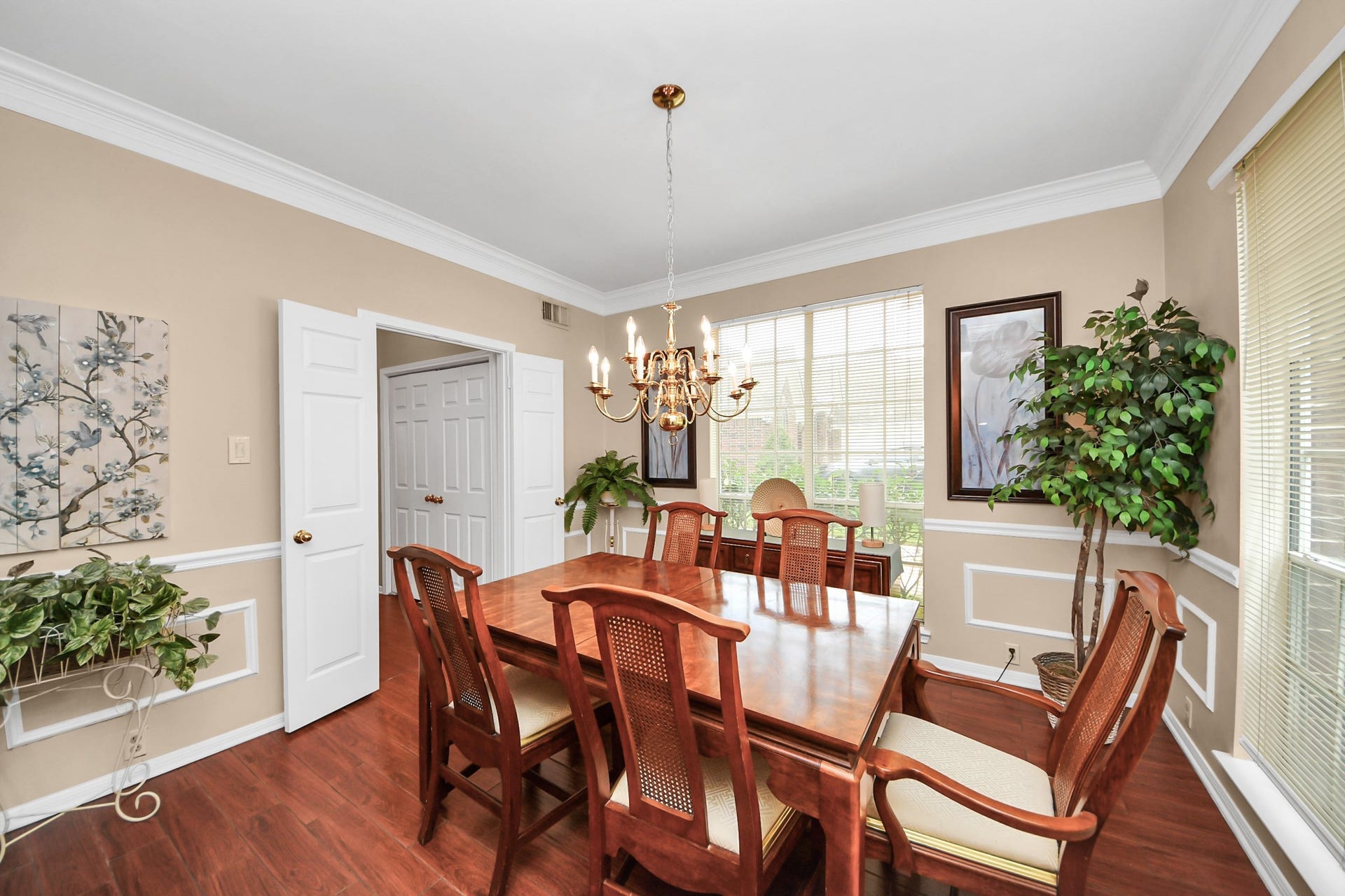 7015 Morningside Drive, Sugar Land, TX 77479 Elegant dining room with rich wood flooring, a classic chandelier, and large windows inviting natural light.