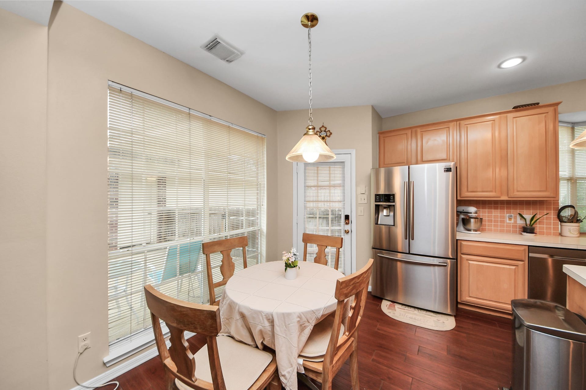 7015 Morningside Drive, Sugar Land, TX 77479 Cozy kitchen nook with warm wooden cabinetry, stainless steel appliances, and a charming dining area bathed in natural light.
