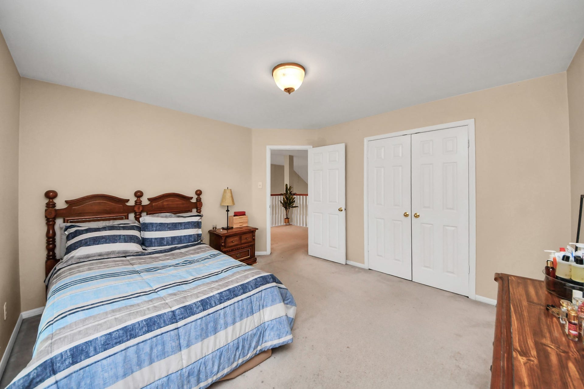 7015 Morningside Drive, Sugar Land, TX 77479 Spacious bedroom featuring a cozy bed, ample closet space with double doors, and a warm, inviting atmosphere.