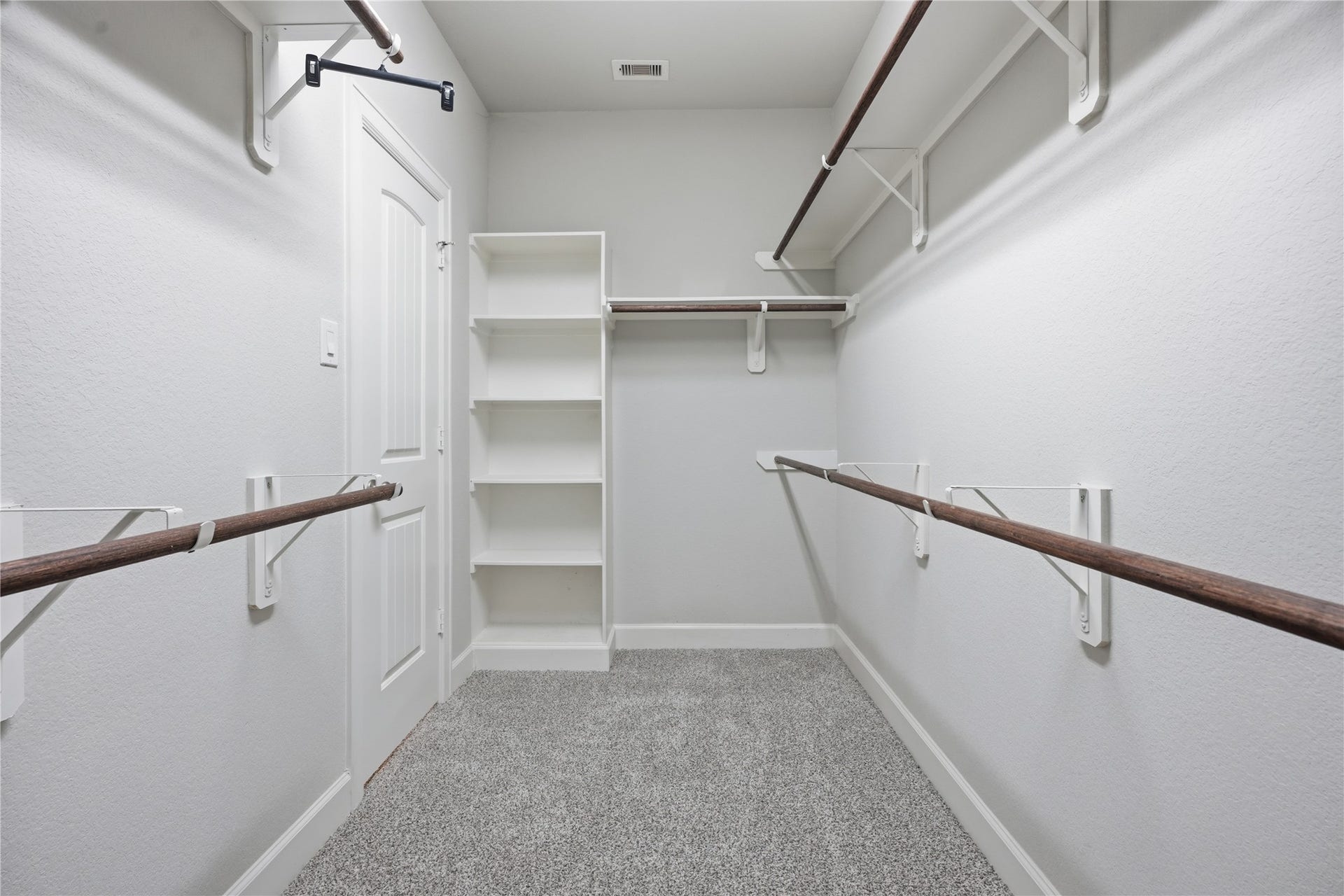 1717 Oakdale Mist Drive, Dickinson, TX 77539 Large walk-in primary closet offers abundant hanging space and built-in shelving for added organization and storage.