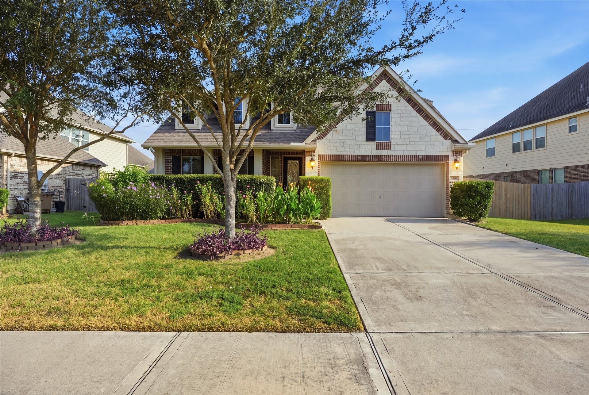 1717 Oakdale Mist Drive, Dickinson, TX 77539 Beautiful curb appeal welcomes you with mature trees, a well-maintained lawn, established landscaping, and an attractive brick and stone exterior.