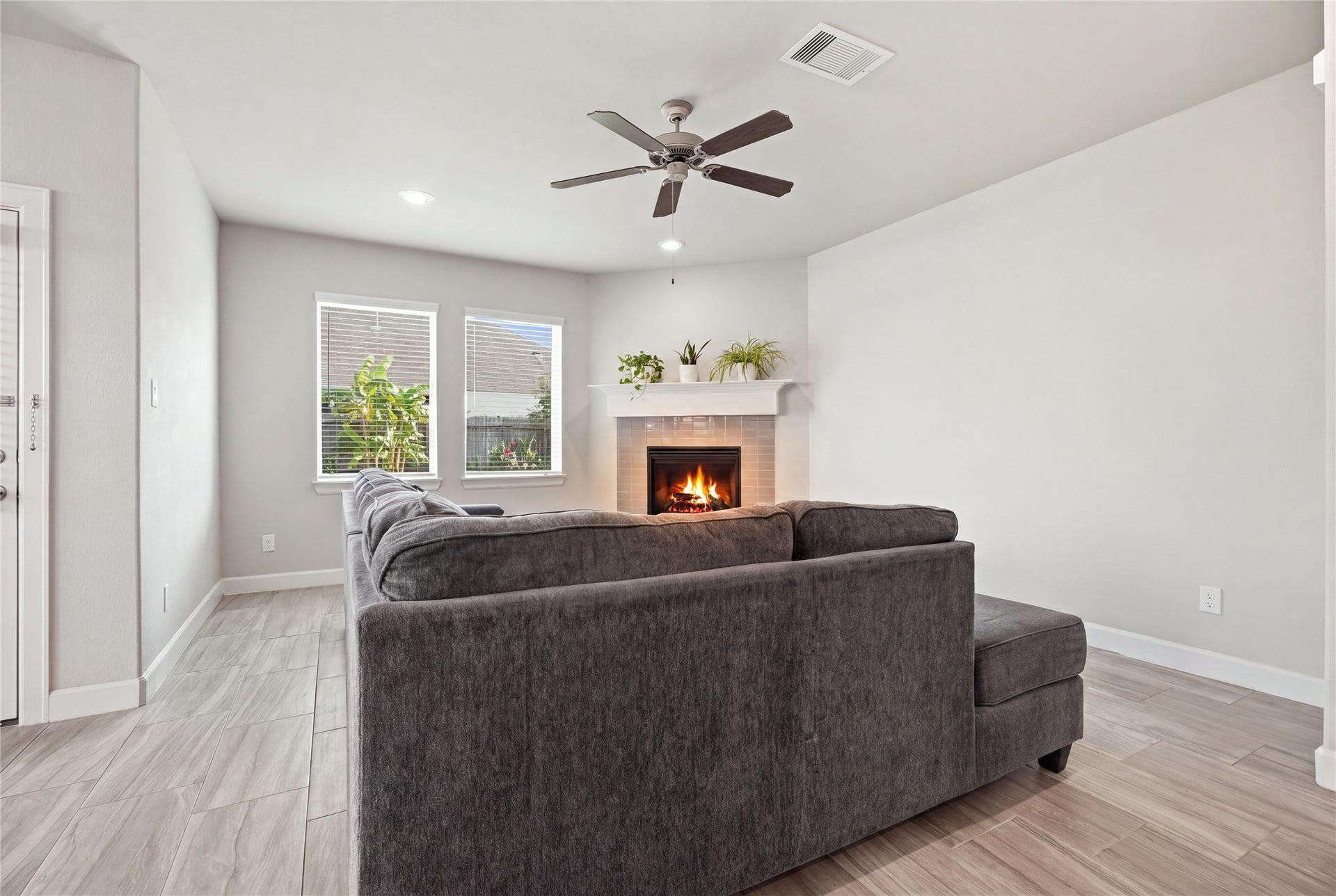 1717 Oakdale Mist Drive, Dickinson, TX 77539 Inviting living room featuring tile flooring, a fireplace, recessed lighting, ceiling fan, and windows overlooking the backyard.