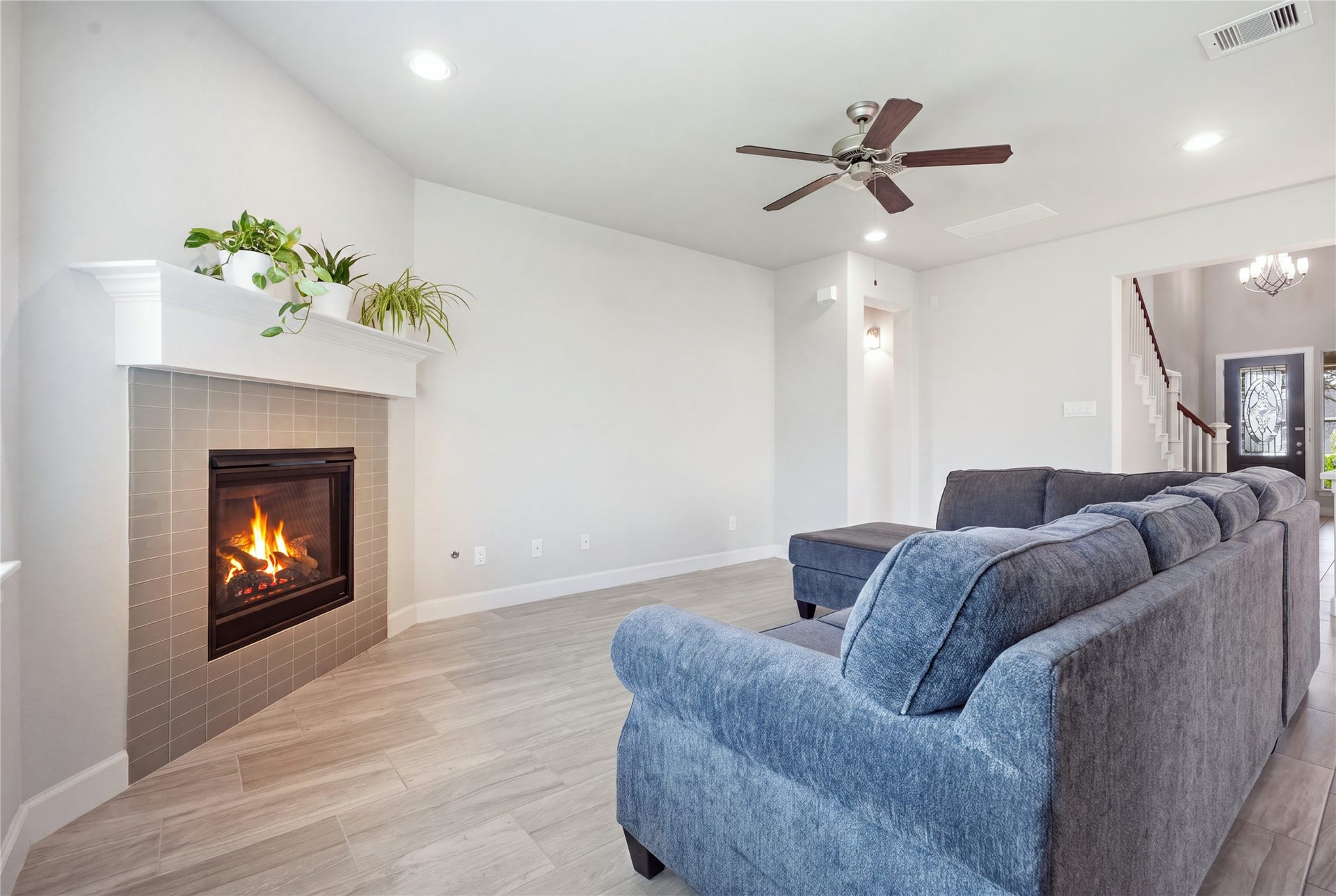1717 Oakdale Mist Drive, Dickinson, TX 77539 Inviting living room features a fireplace with a striking floor-to-ceiling surround, creating an eye-catching focal point in the space.