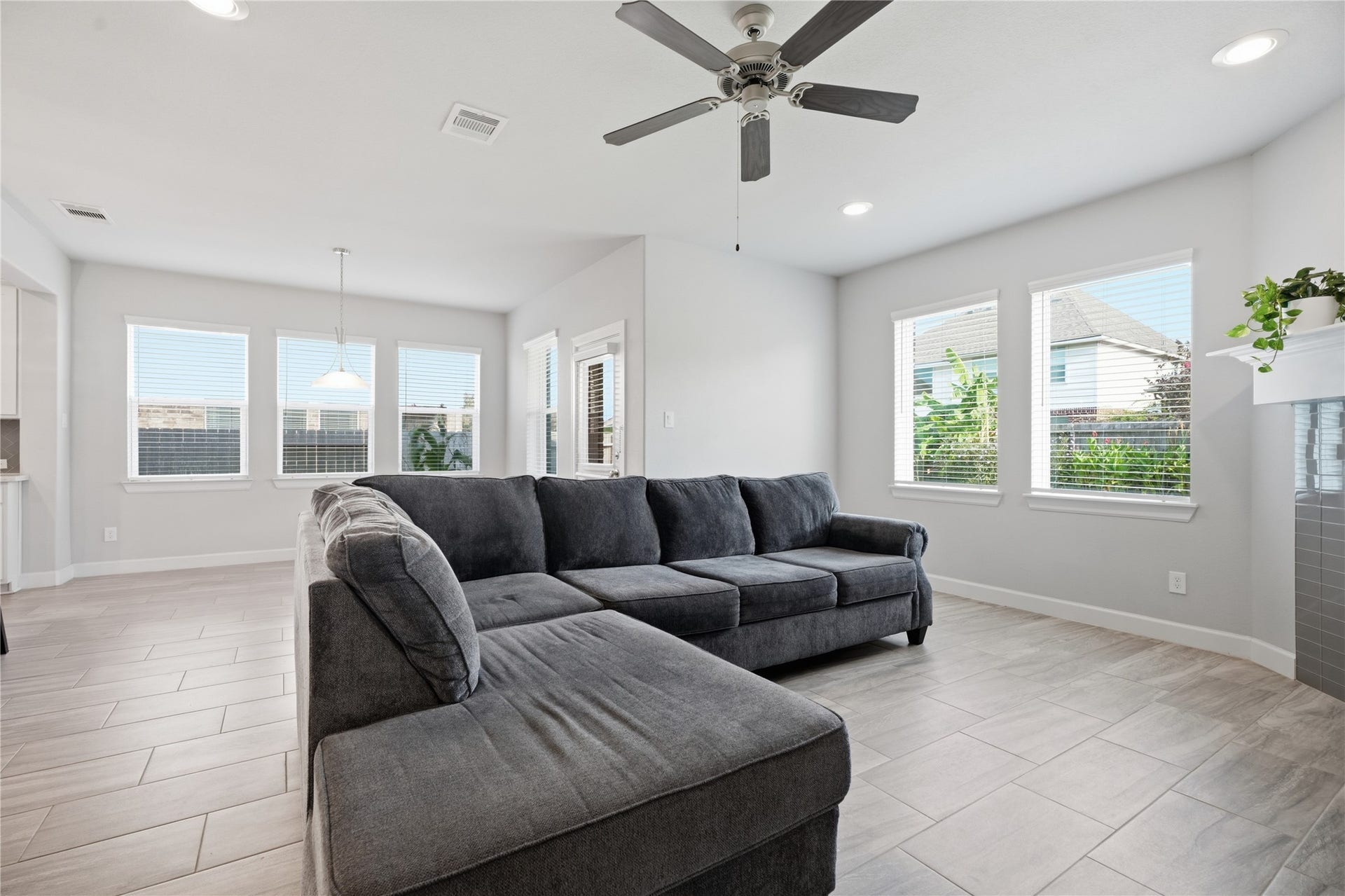 1717 Oakdale Mist Drive, Dickinson, TX 77539 Spacious living room featuring tile flooring, a fireplace, recessed lighting, and plenty of natural light from the surrounding windows.