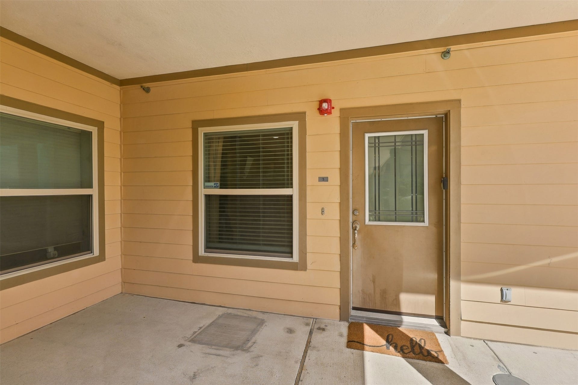 3501 Chenevert Street, #3, Houston, TX 77004 Inviting entryway with a warm, neutral exterior, featuring a welcoming doormat and ample natural light through the windows.