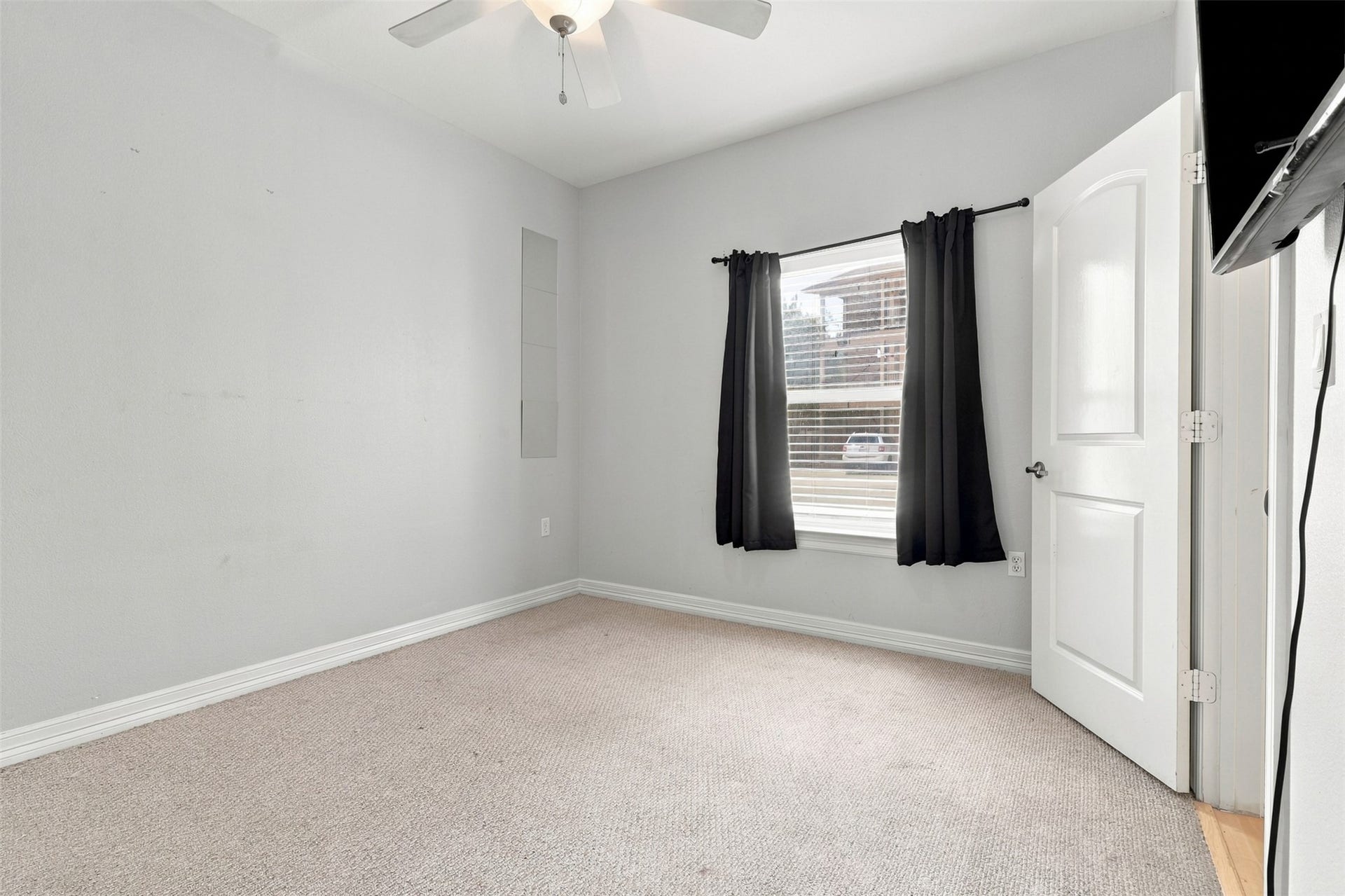 3501 Chenevert Street, #3, Houston, TX 77004 Bright and inviting bedroom featuring neutral tones, plush carpeting, and a ceiling fan, offering comfort and style.